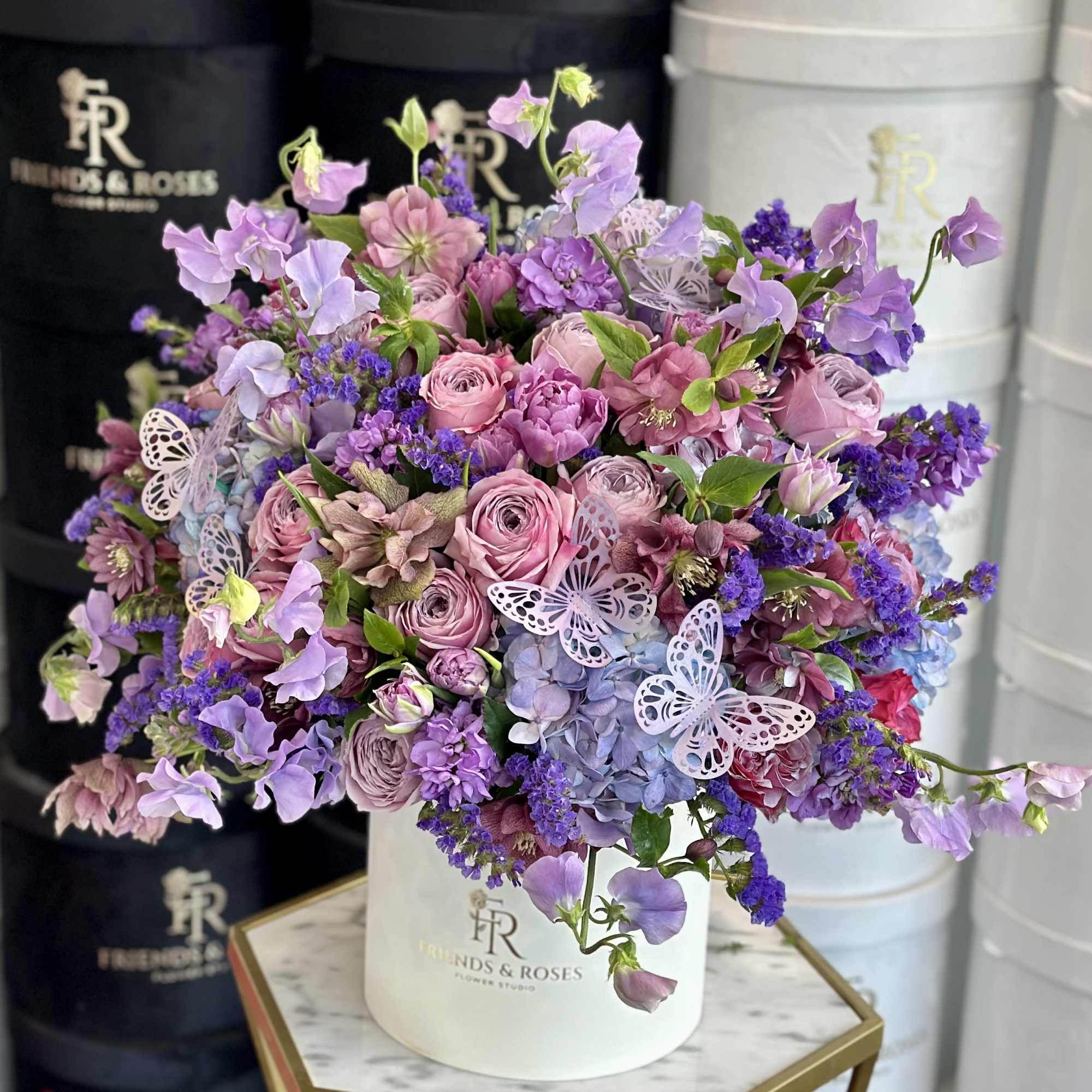 Lavender and pink bouquet in a white hat box with butterfly accents