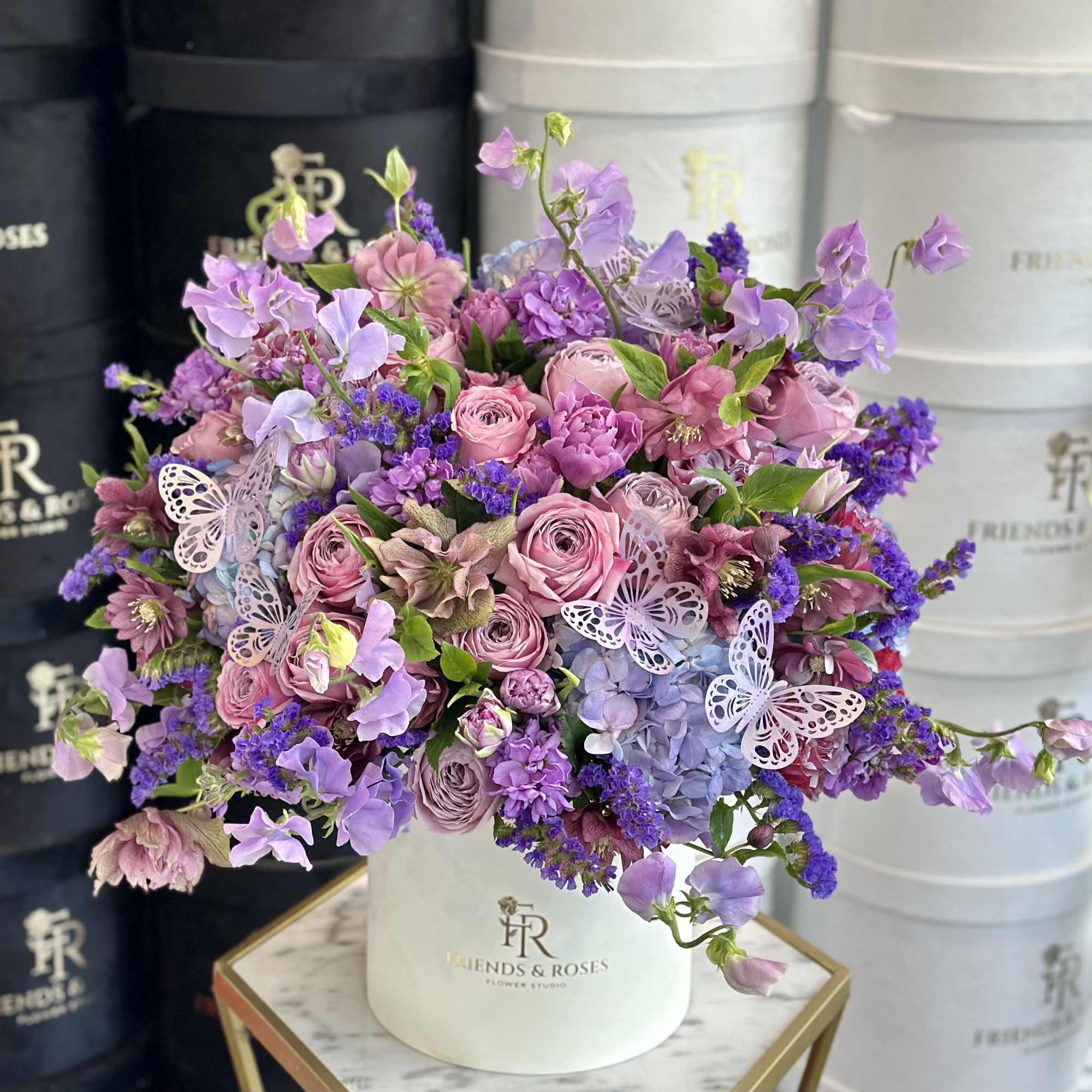 Lavender and pink bouquet in a white hatbox with butterfly accents