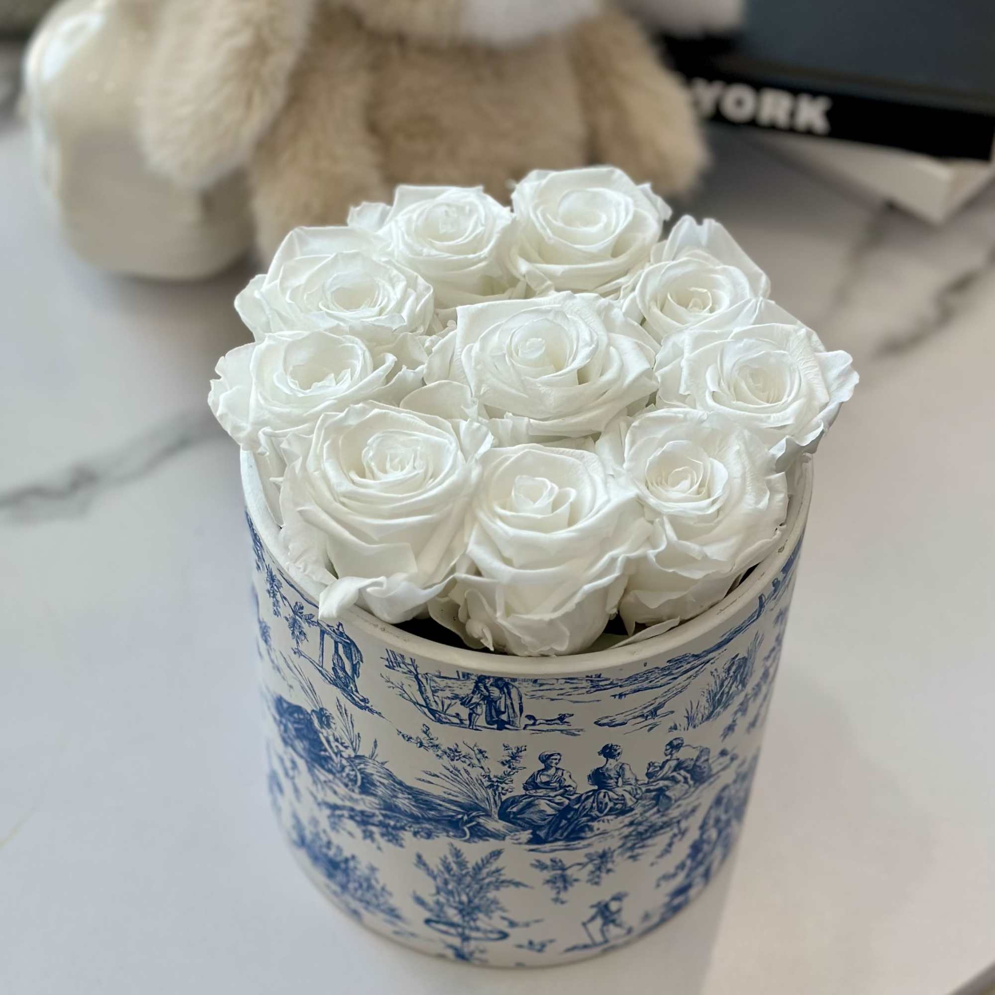 White roses arranged in a blue-and-white decorative box