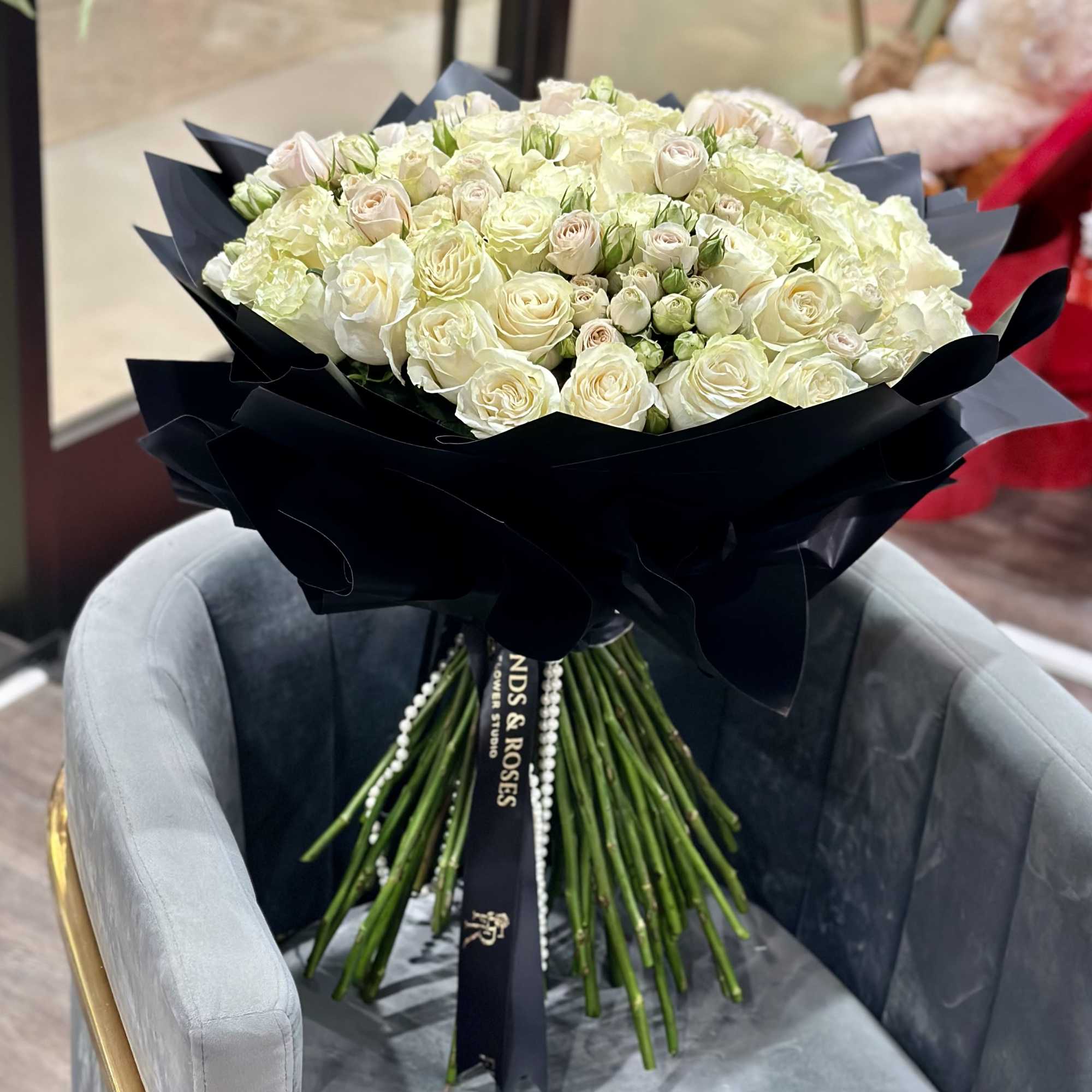 Large bouquet of white roses wrapped in black paper