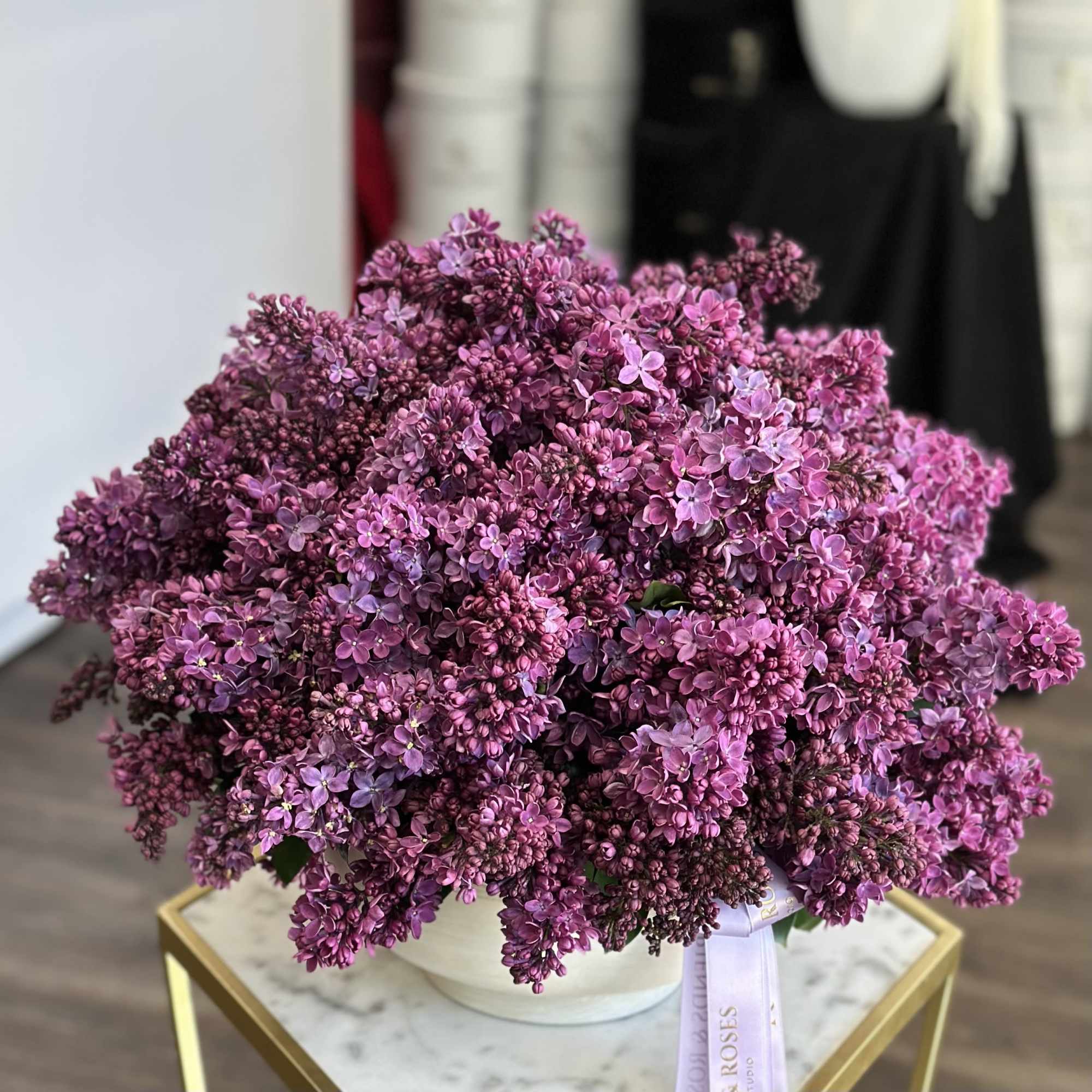 Large bouquet of purple lilac flowers in a white container