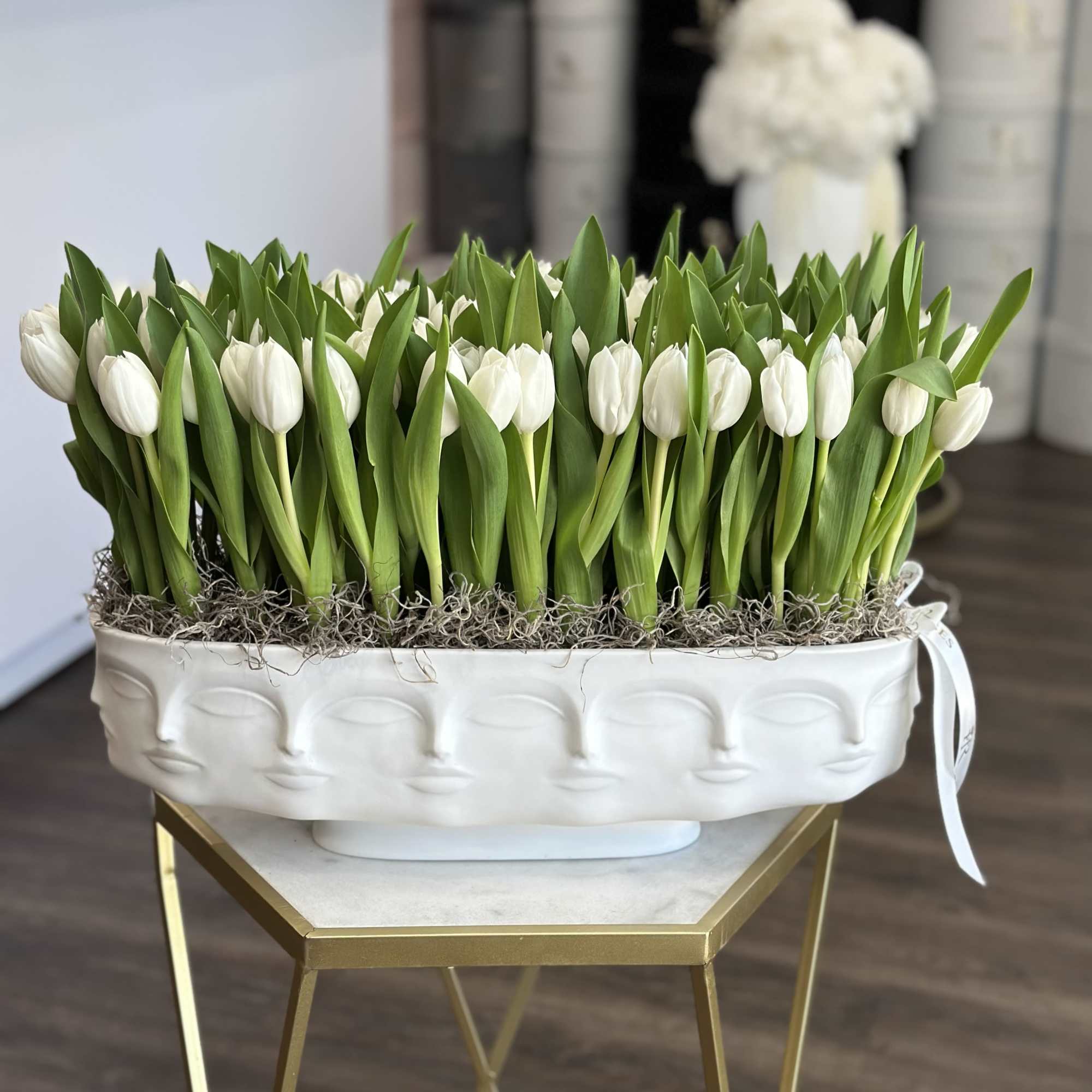 White tulips arranged in a decorative white planter