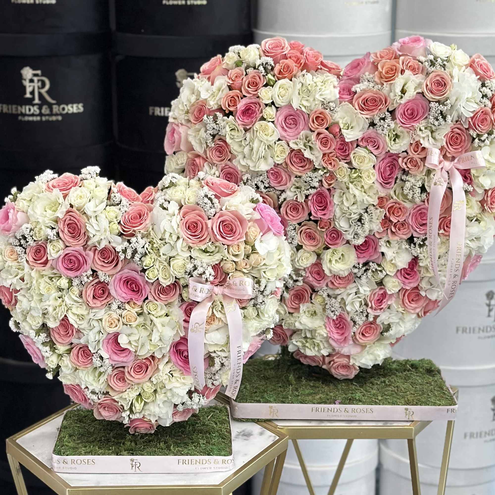 Heart-shaped rose arrangements in pink and white on gold stands