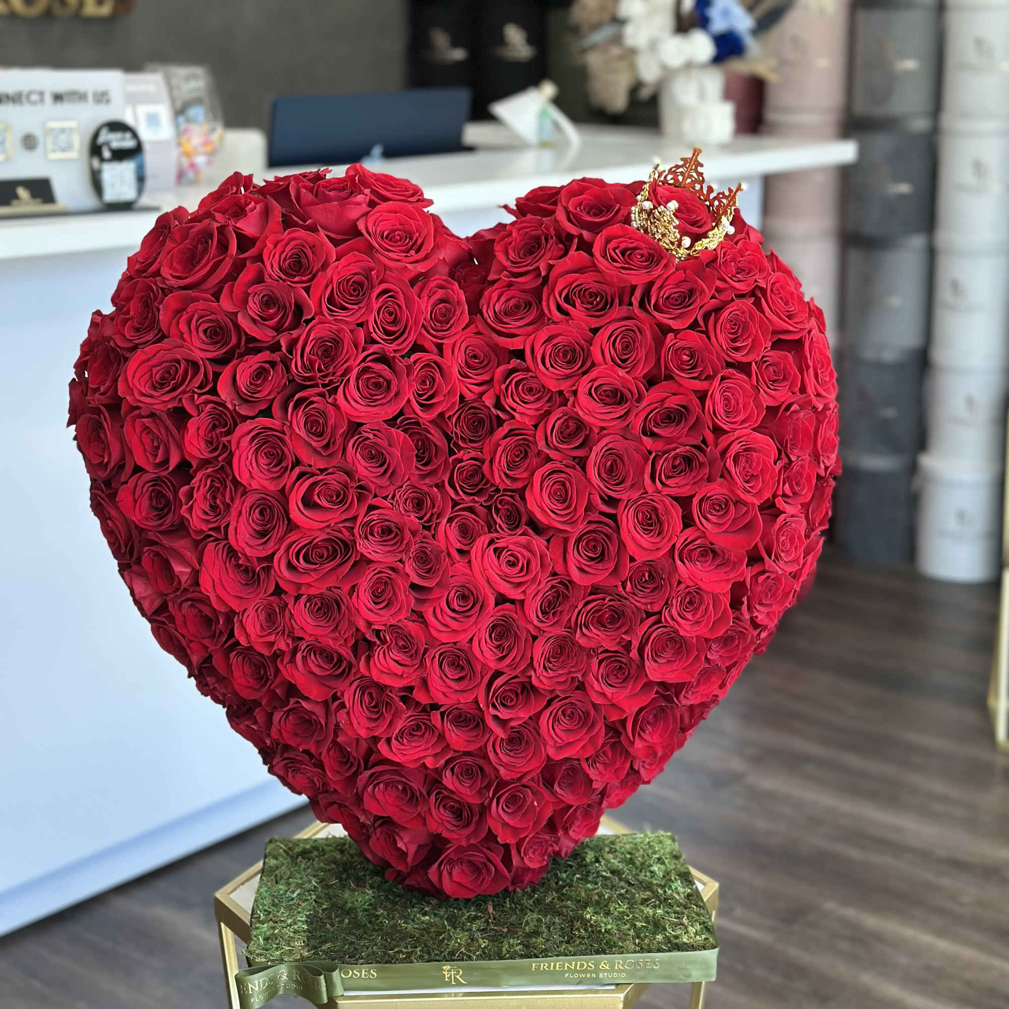 Heart-shaped arrangement of red roses on a moss-covered base, photo 2 of 3