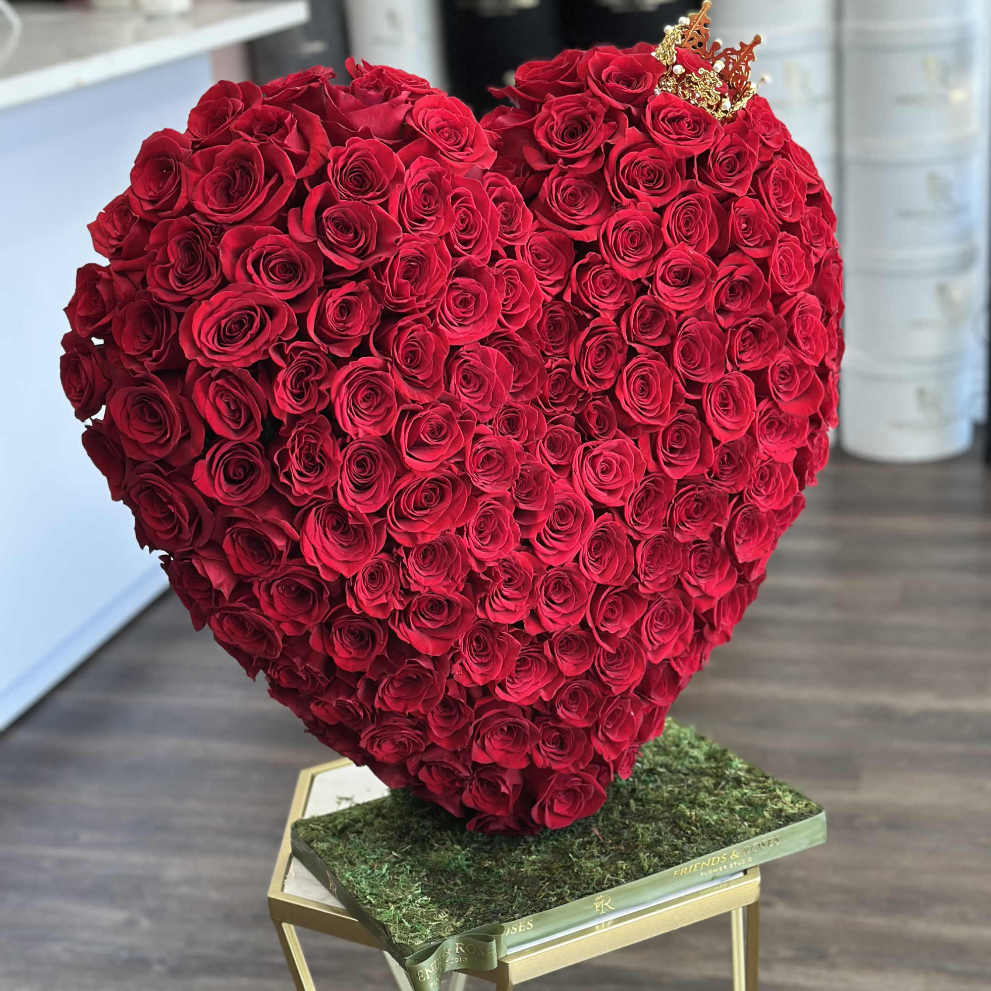 Heart-shaped arrangement of red roses on a moss-covered base, photo 3 of 3