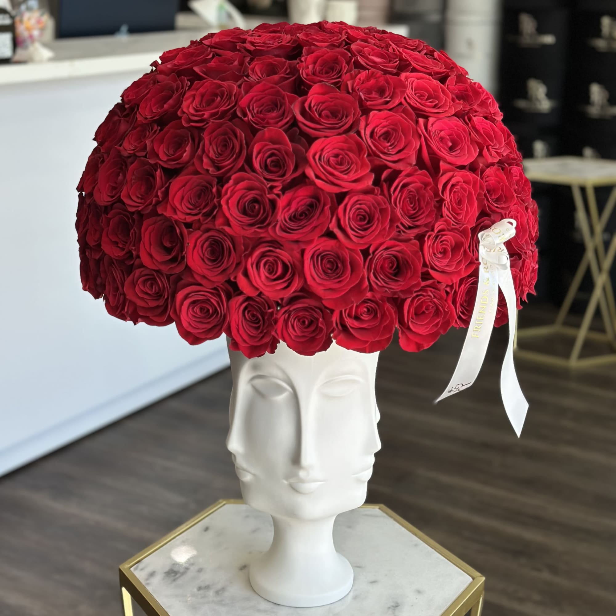 Large dome of red roses in a white sculptural vase