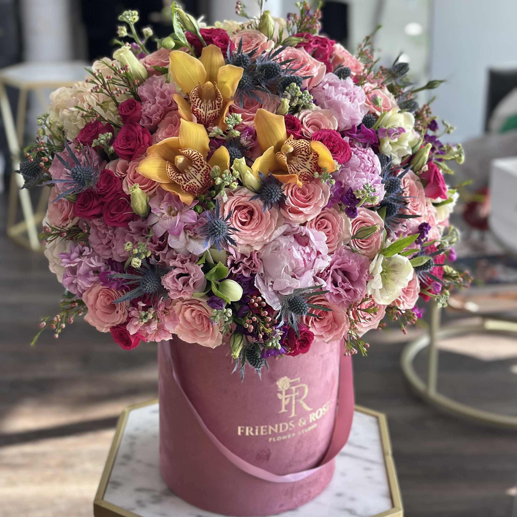 Large pink and yellow mixed bouquet in a round hatbox