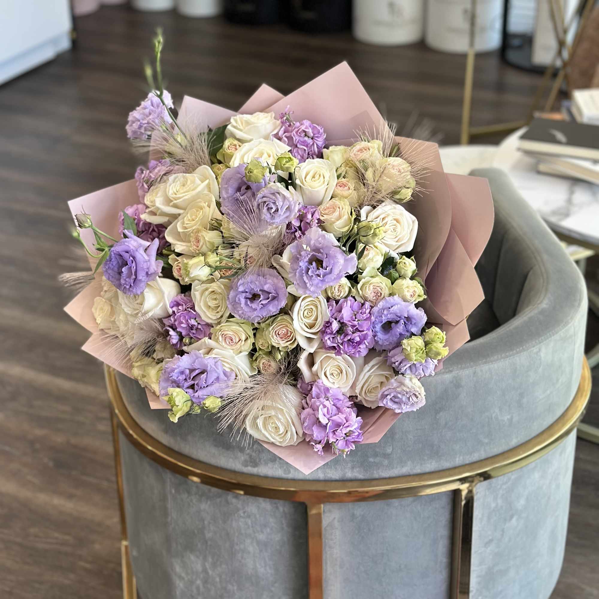 Bouquet of cream and lavender roses with pink wrapping