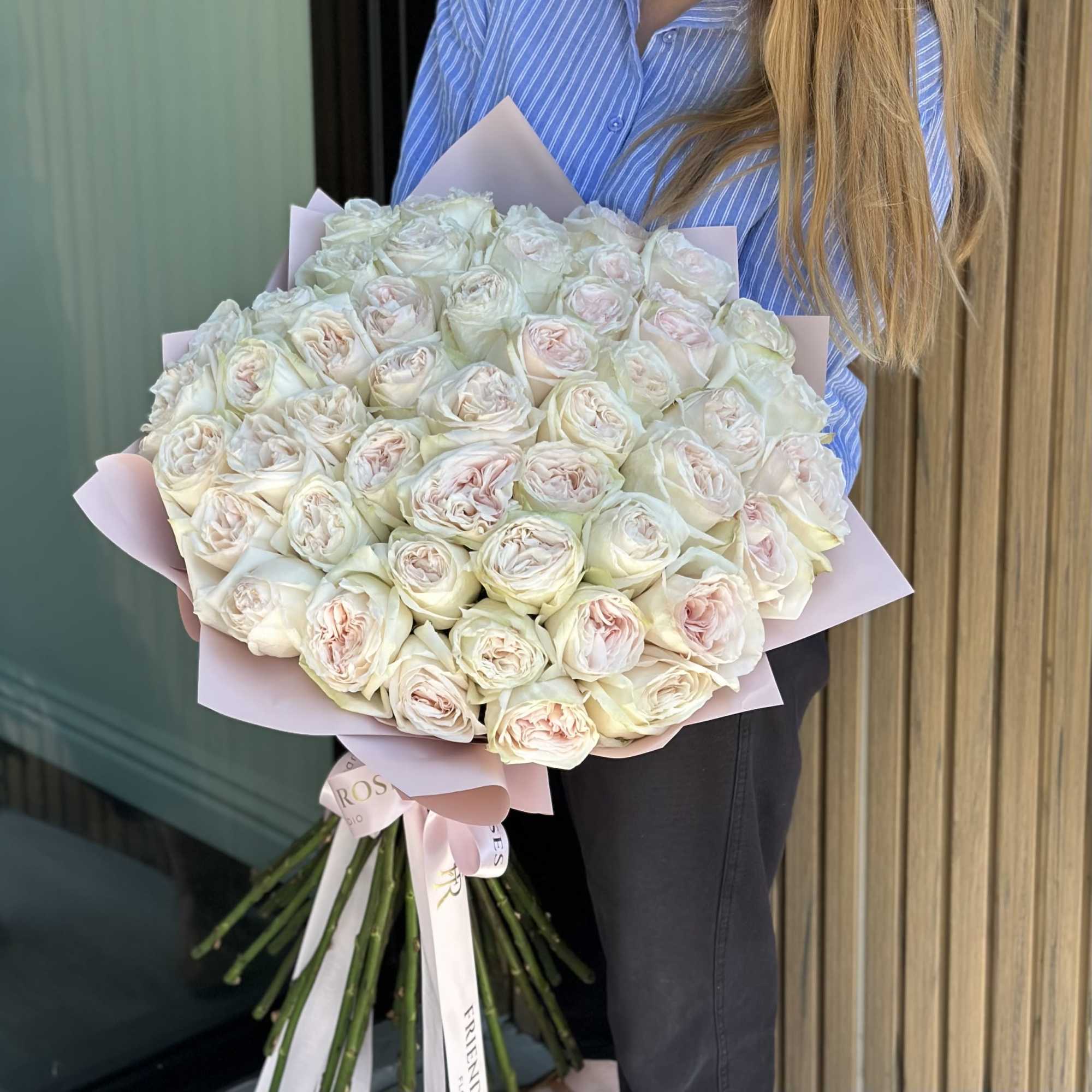Large bouquet of pale pink and white roses wrapped in pink paper, photo 2 of 3