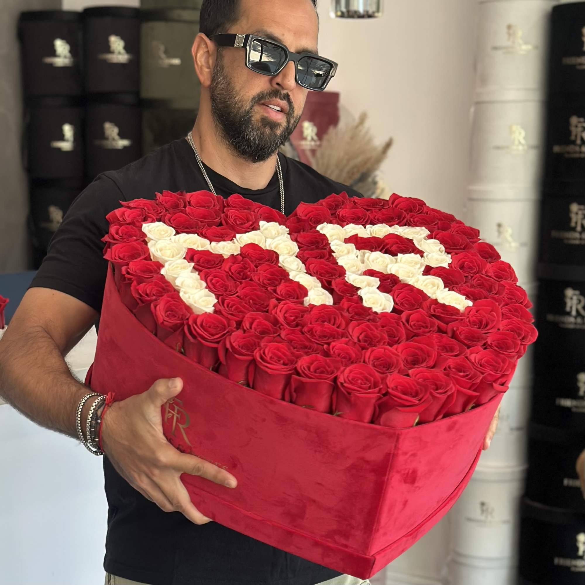Heart-shaped box of red and white roses held by a man, photo 2 of 4