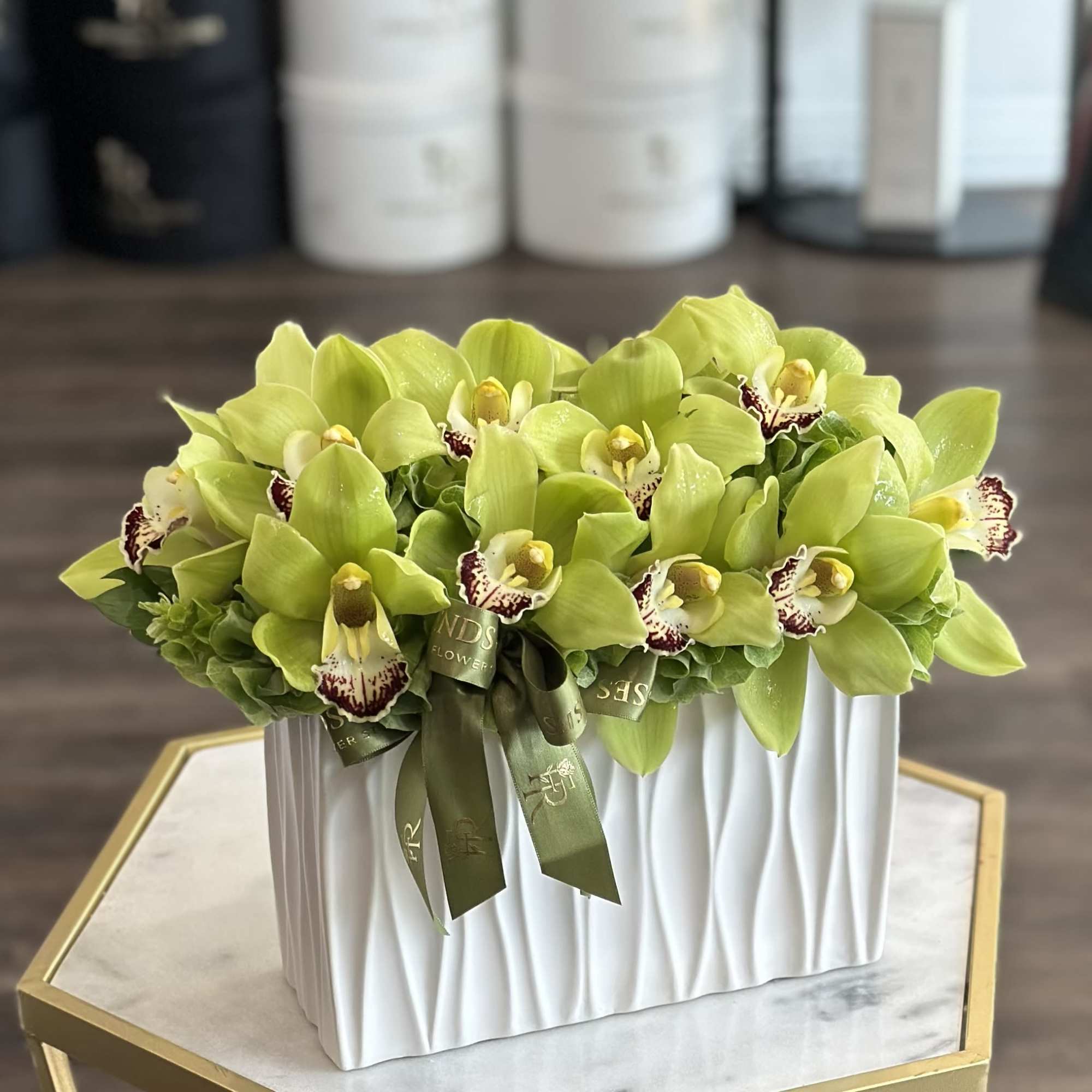 Green orchid arrangement in a white rectangular vase with ribbon, photo 2 of 3