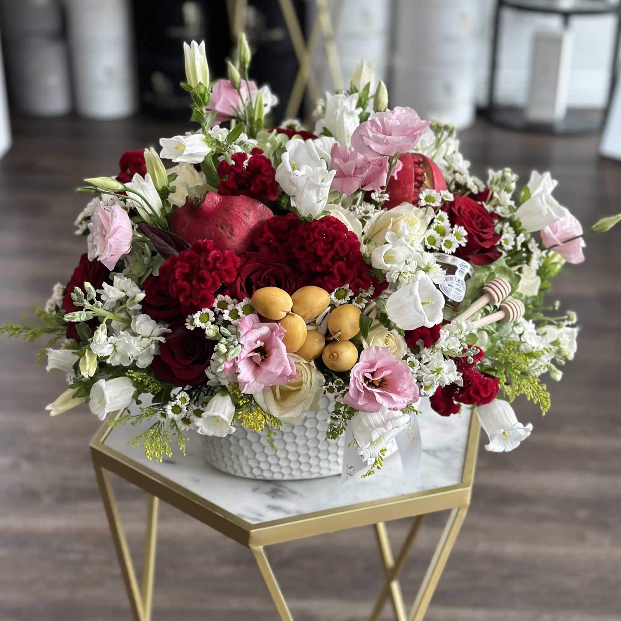Mixed bouquet of red, pink, and white flowers in a white vase