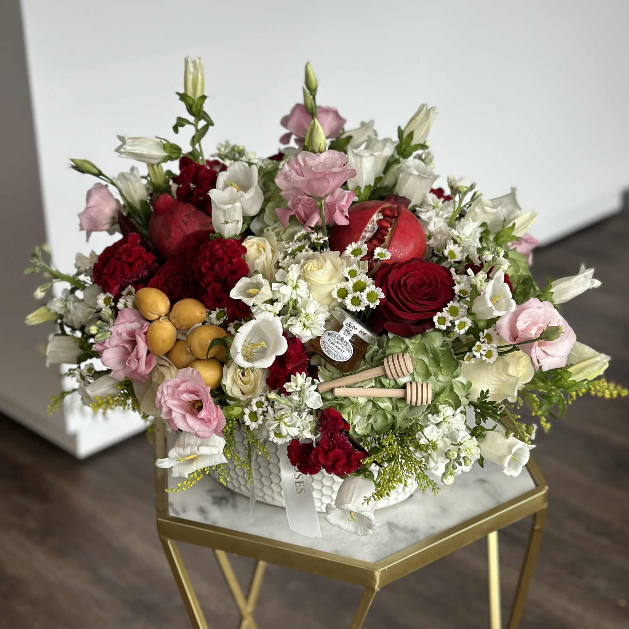 Mixed bouquet with red, white, and pink flowers in a white container