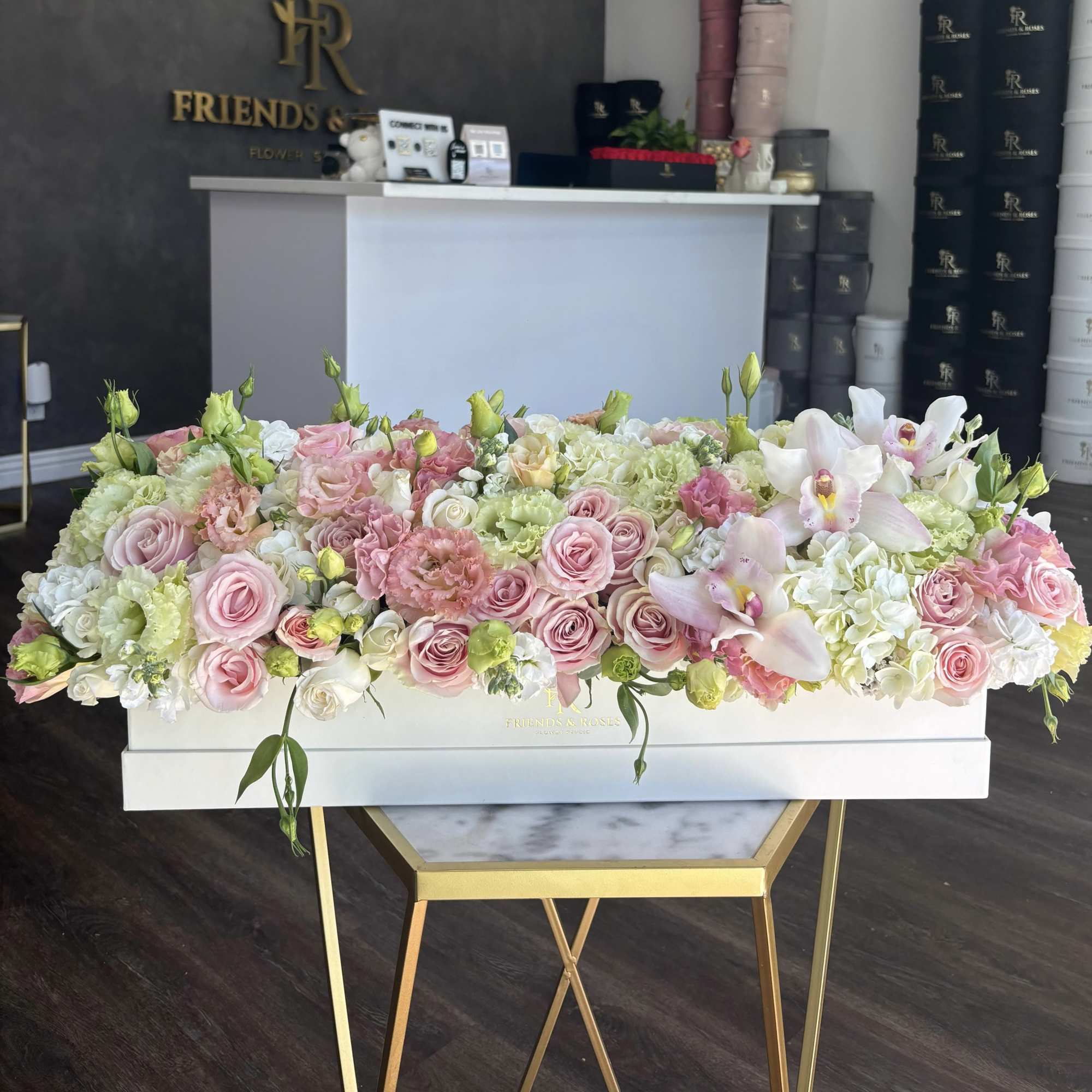 Large pastel flower arrangement in a white box with pink roses and white orchids