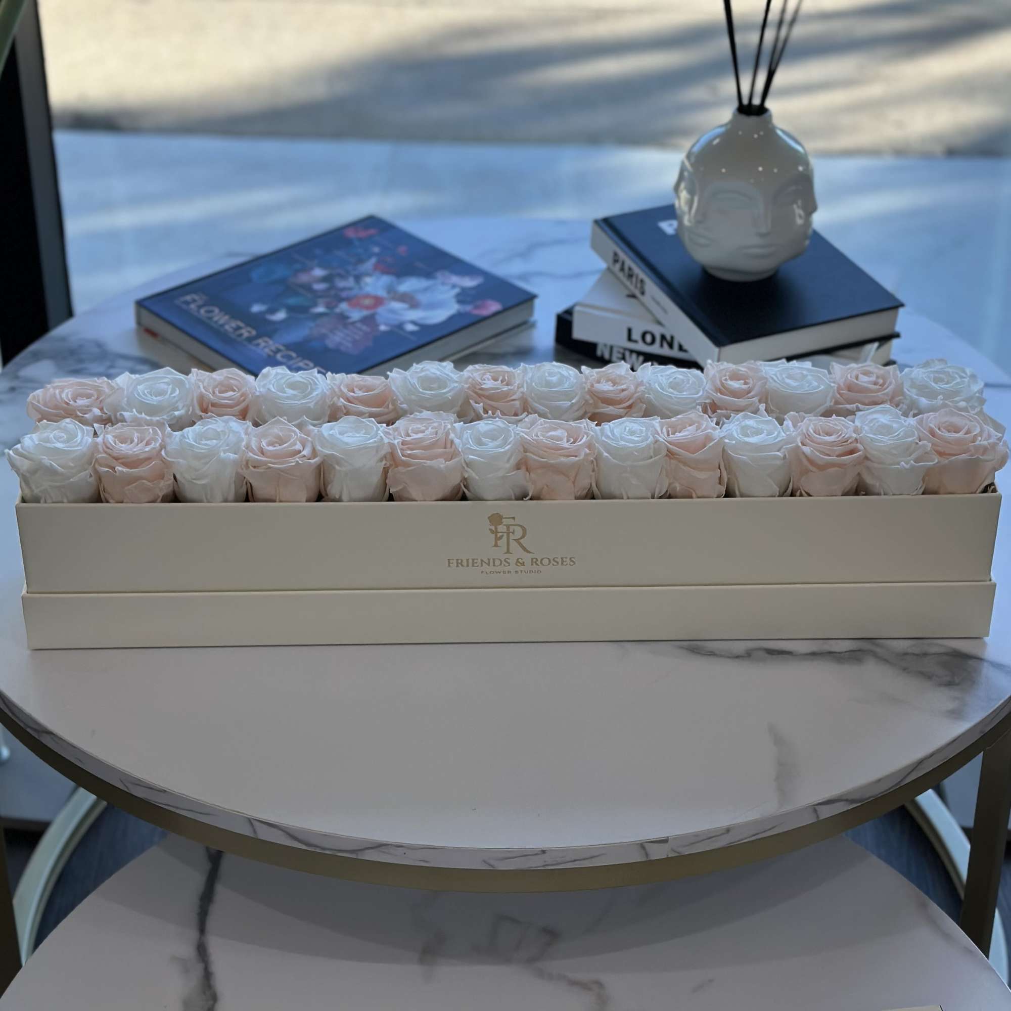 Box of pale pink and white roses on a table