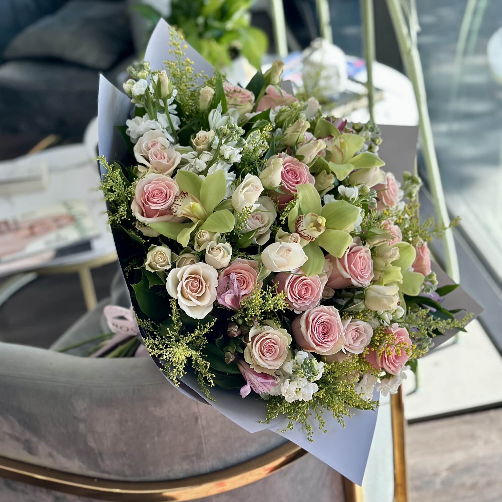 Bouquet of pink and white roses with green orchids