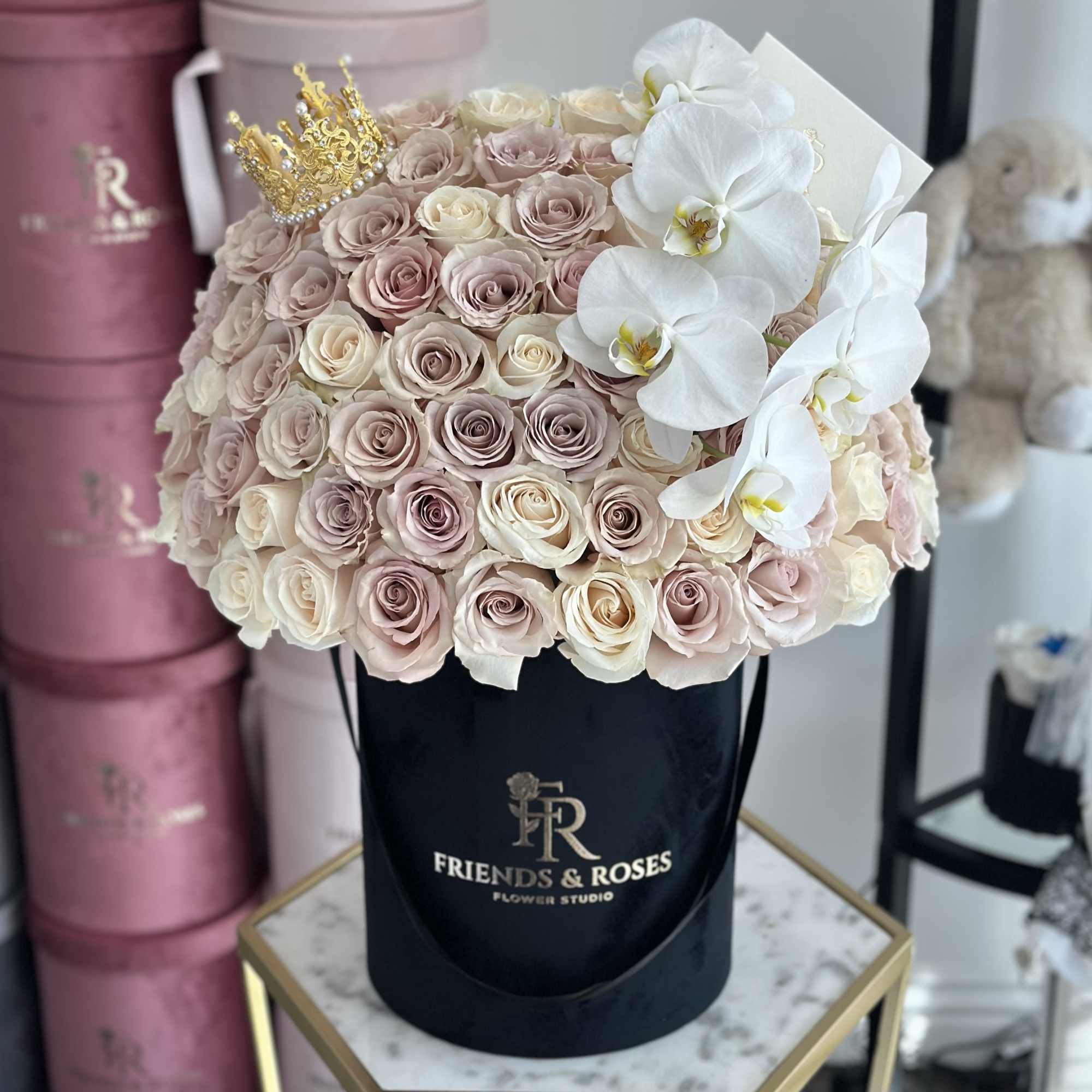 Round bouquet of blush roses and white orchids in a black hat box