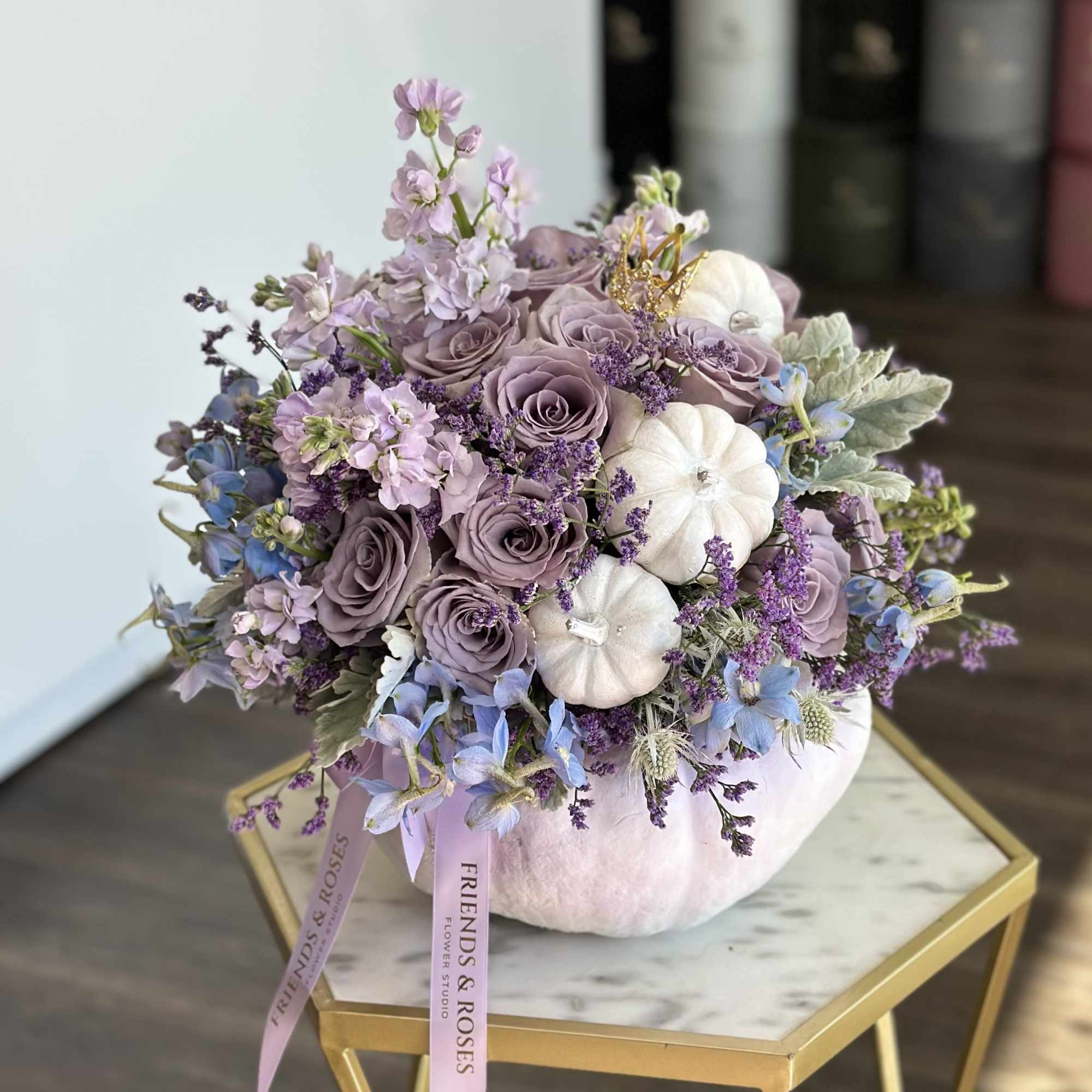 Lavender rose bouquet arranged in a white pumpkin vase