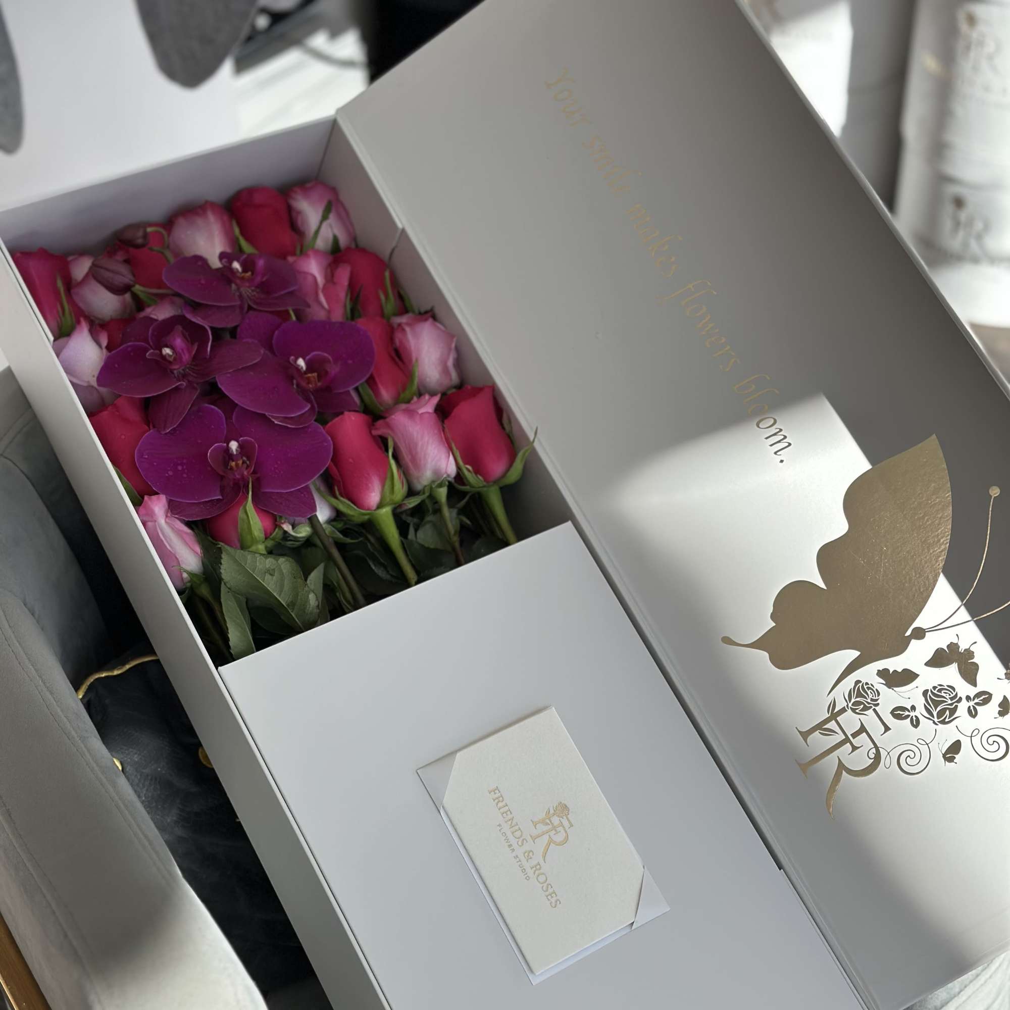 Box of pink roses with purple orchids