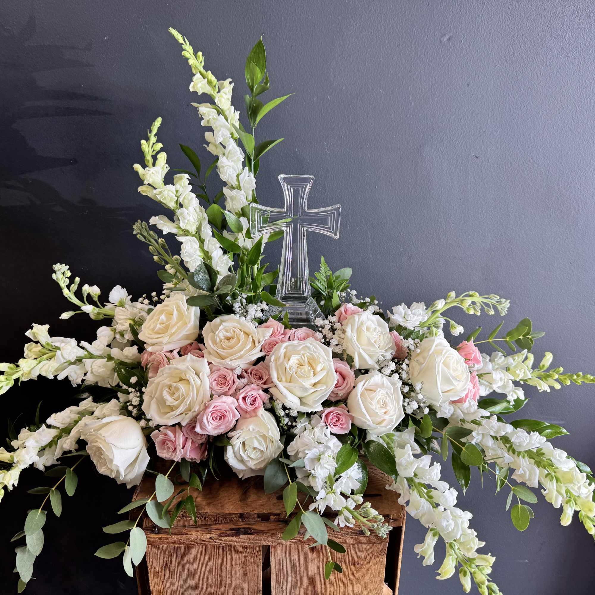 White and pink rose arrangement with a clear cross centerpiece