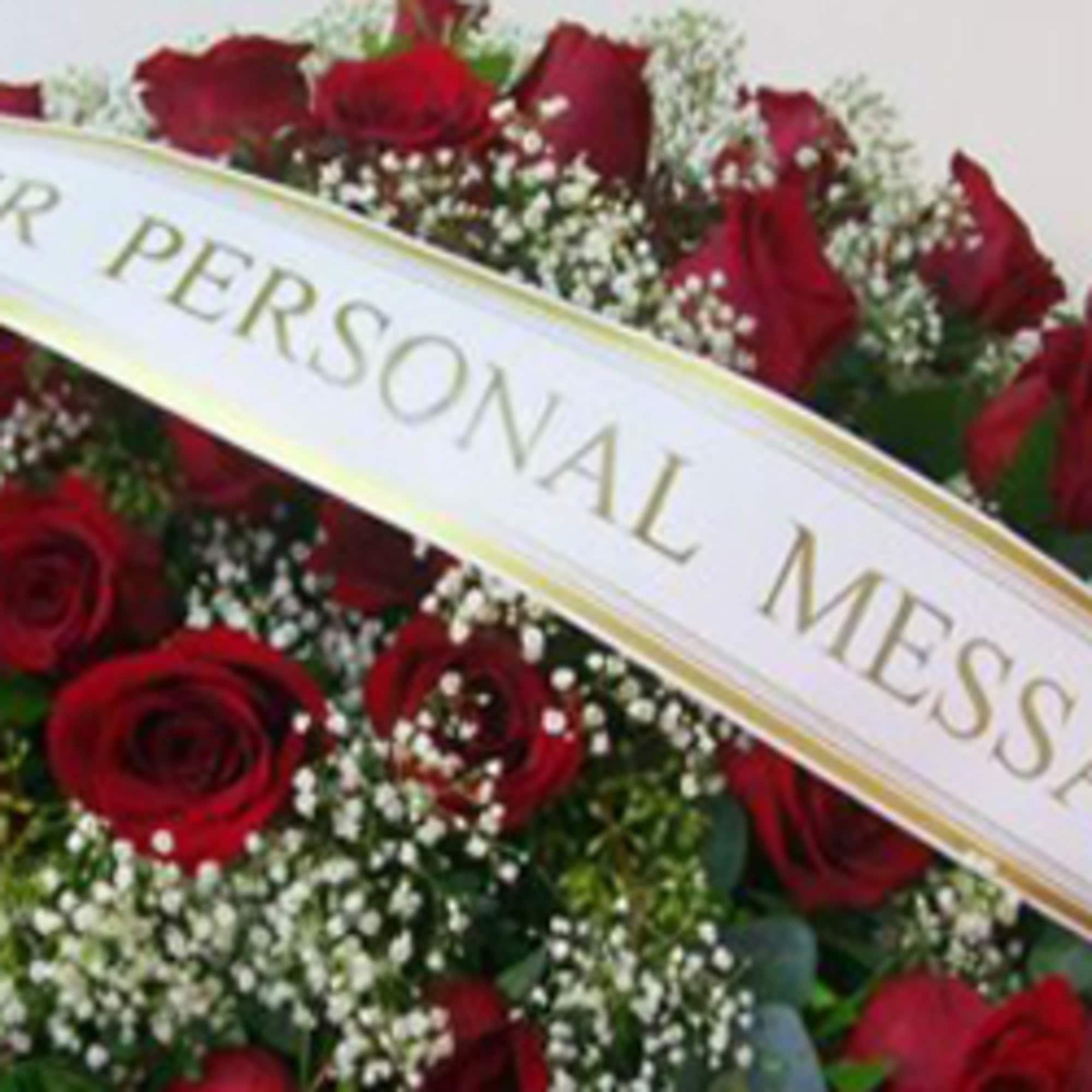 Red roses with baby's breath and a memorial ribbon