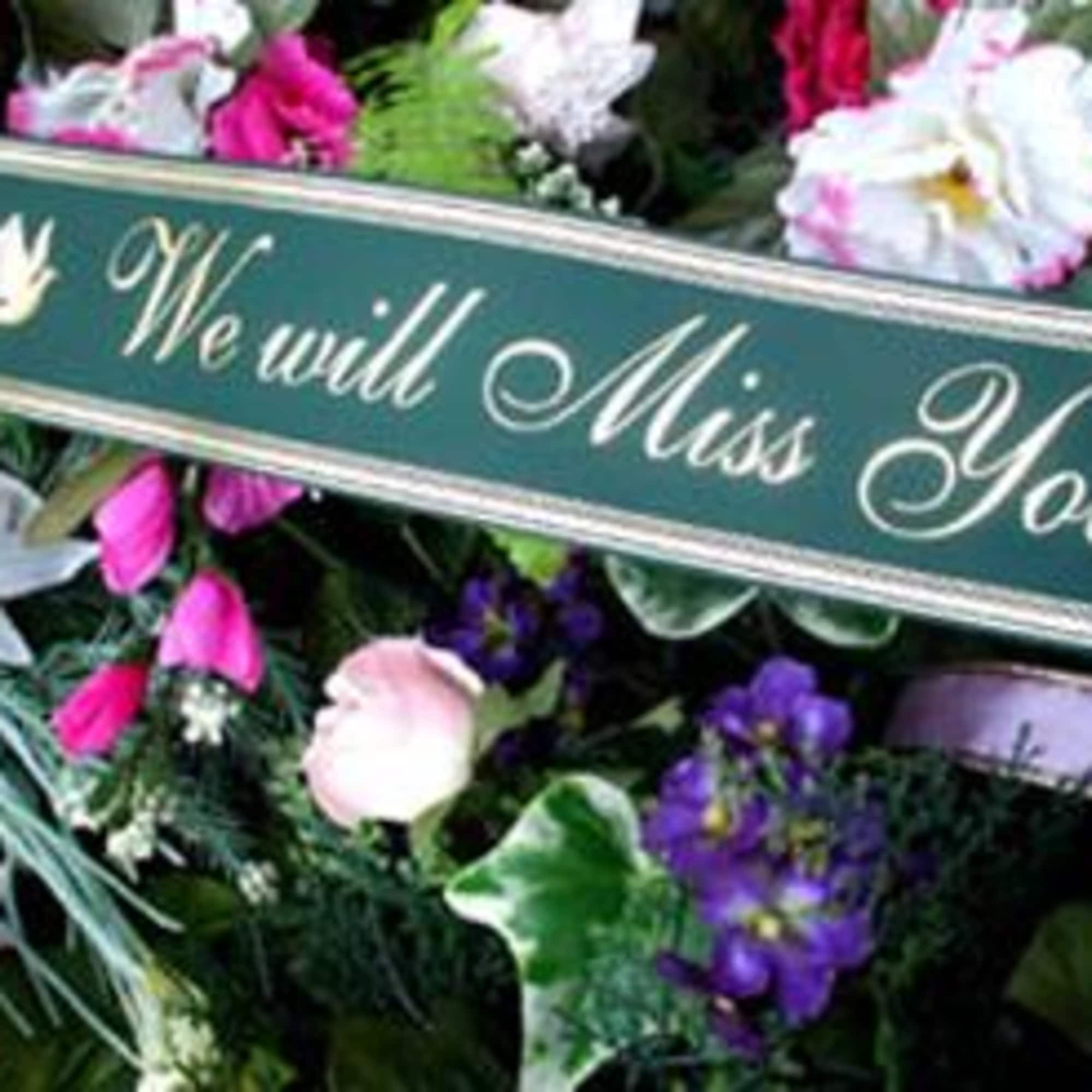 Floral funeral tribute with a sign reading We will Miss You