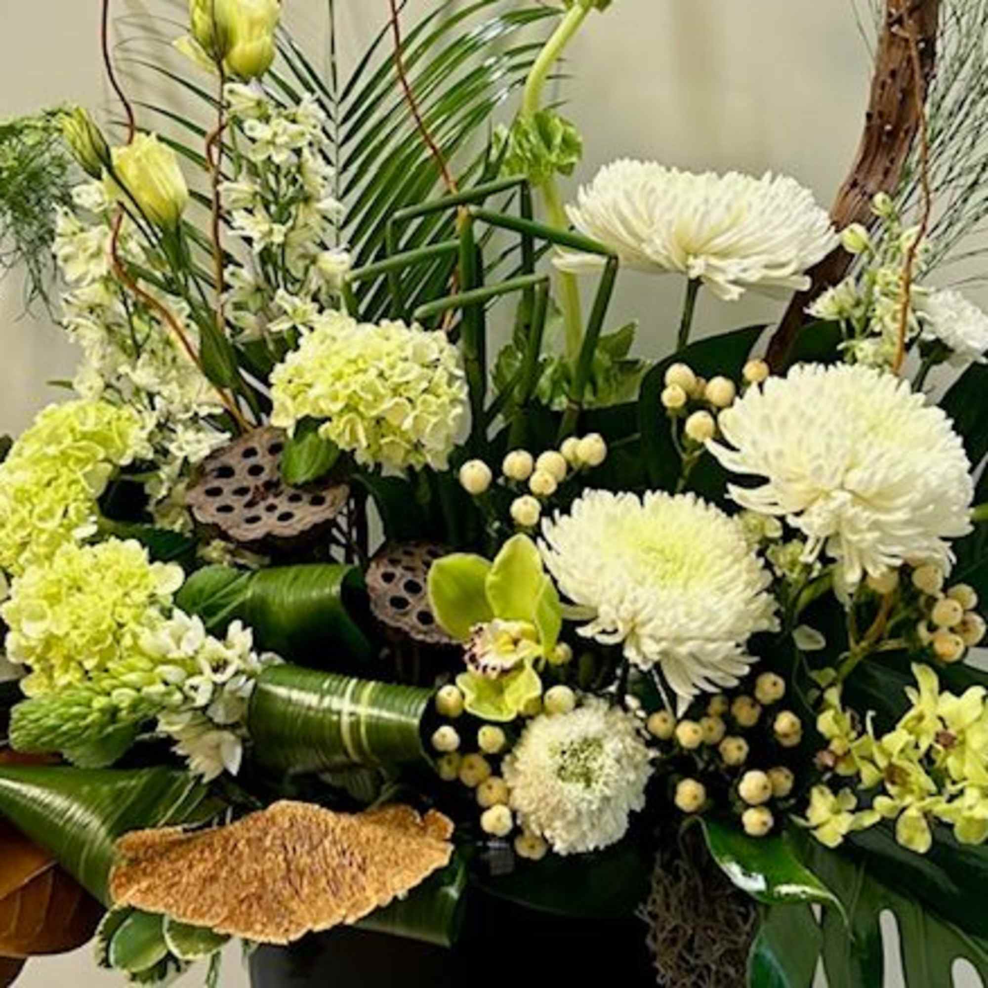 White and pale green floral arrangement with orchids and chrysanthemums