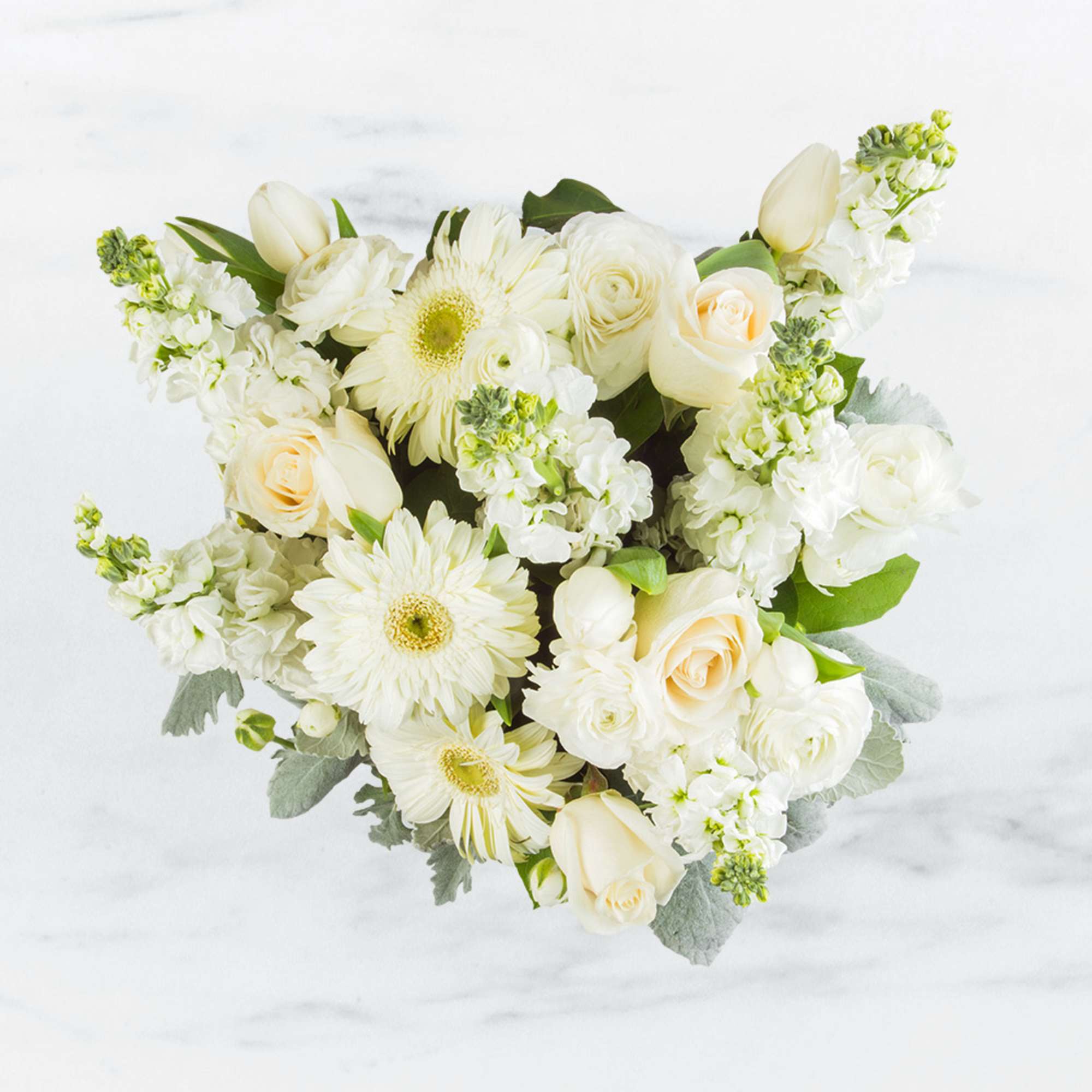 This arrangement contains gerbera daisies, roses, tulips, stock, and other seasonal blooms., photo 2 of 2