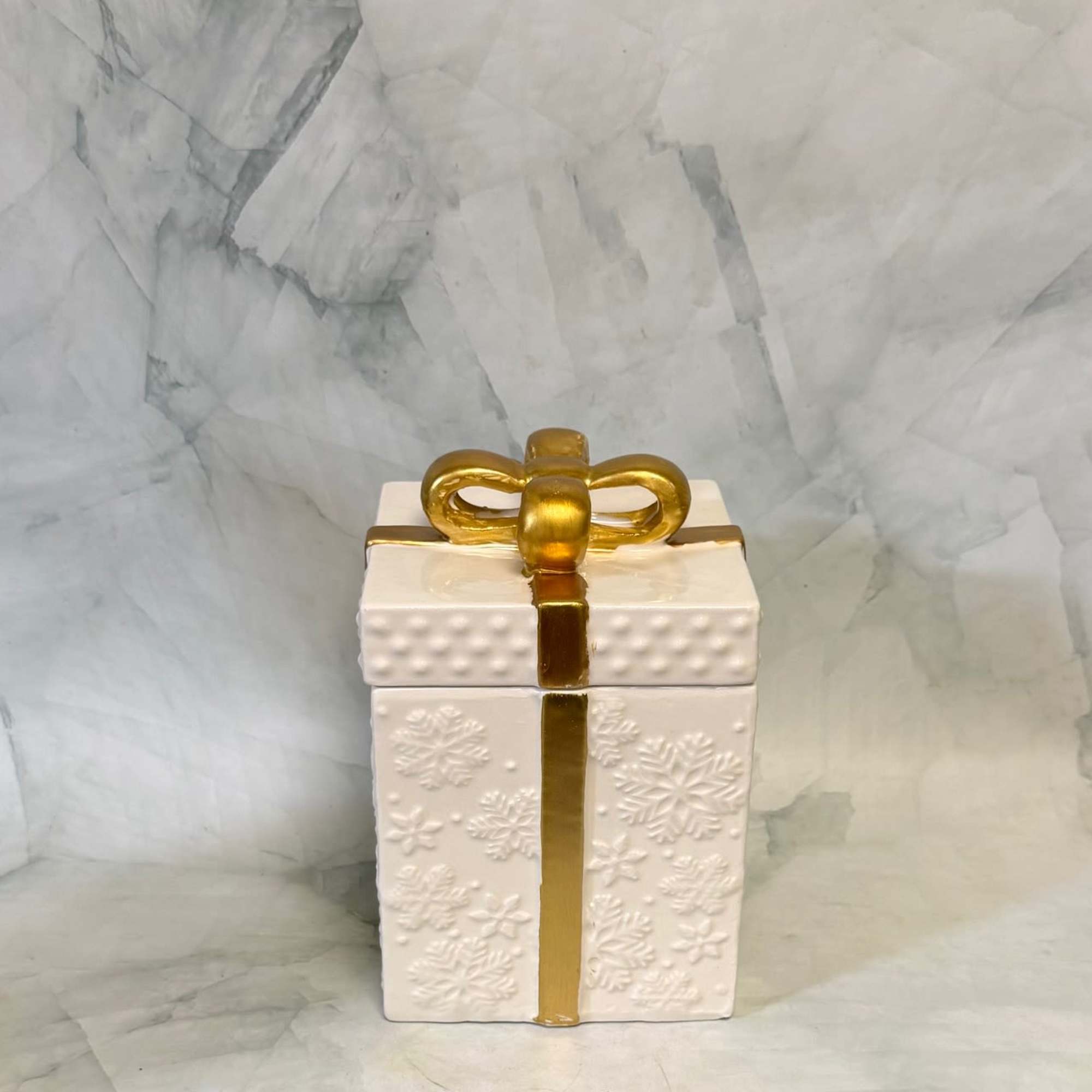 White gift box with a gold ribbon and bow