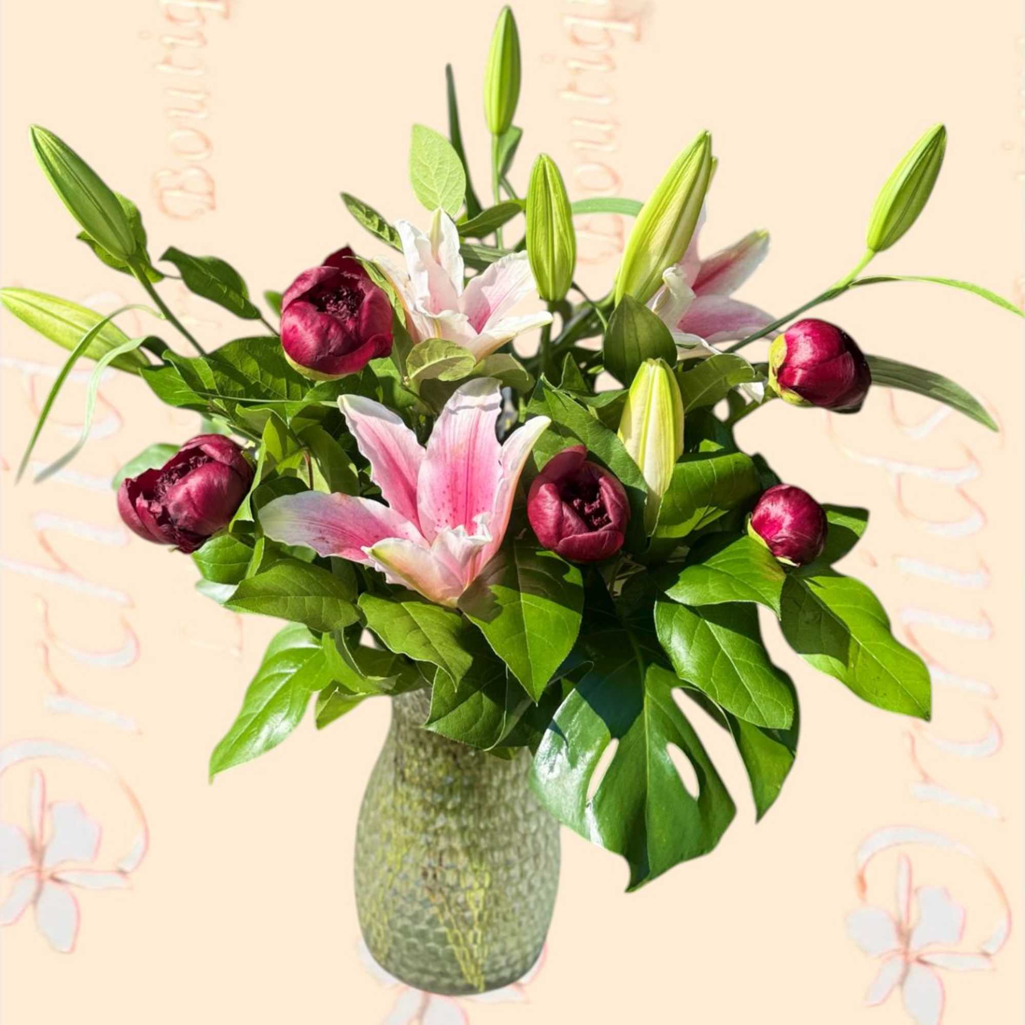 Pink lilies and burgundy buds in a green glass vase