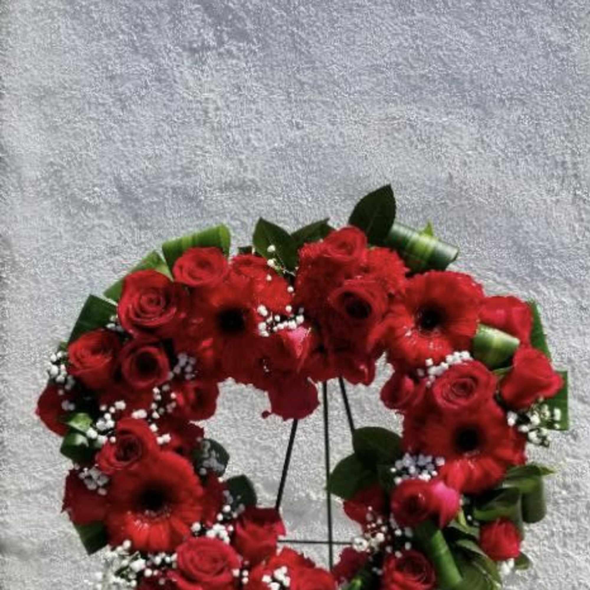 Heart-shaped red flower wreath on a stand