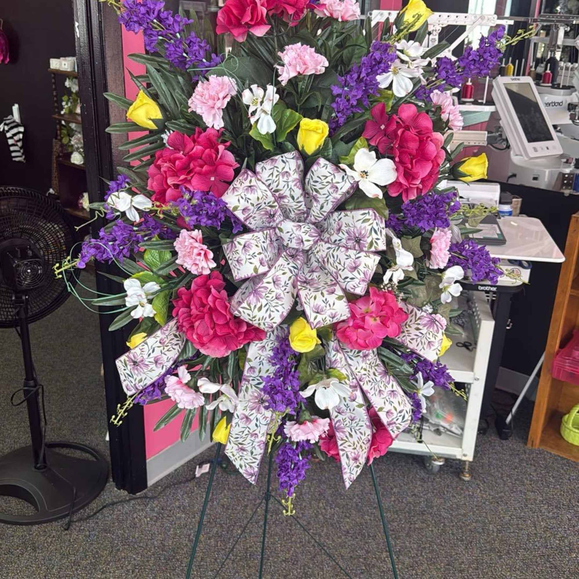 Large standing floral spray with pink, purple, yellow, and white flowers