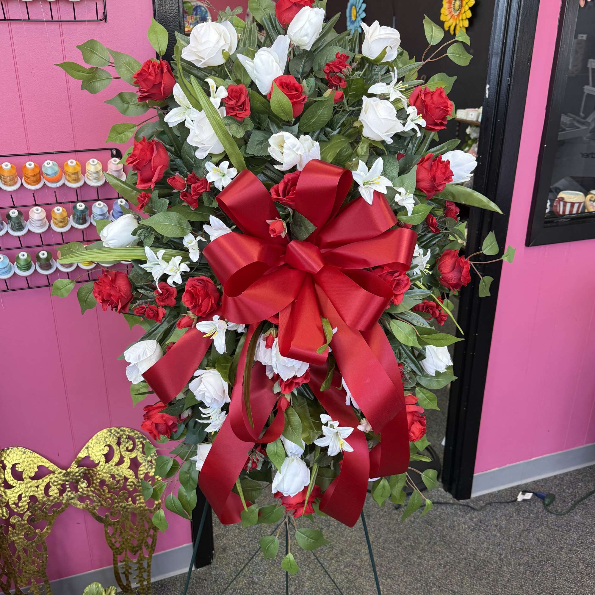 Large red and white rose standing spray with a red ribbon bow