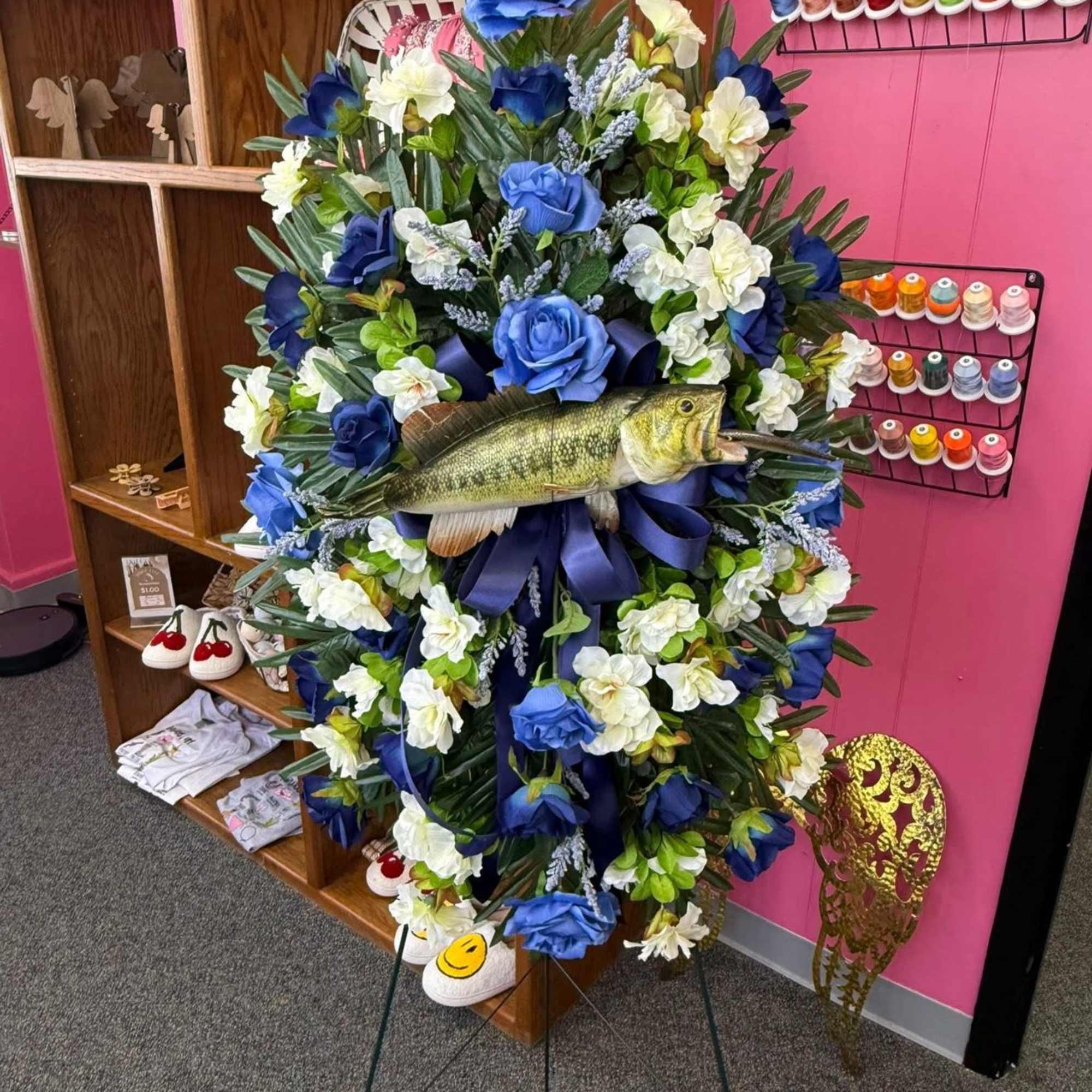 Large floral wreath with a fish centerpiece on a stand
