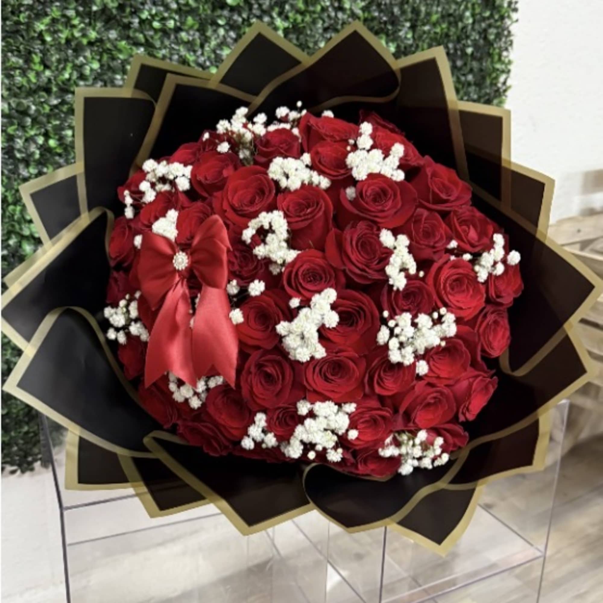 Bouquet of red roses with white baby's breath in black and gold wrap