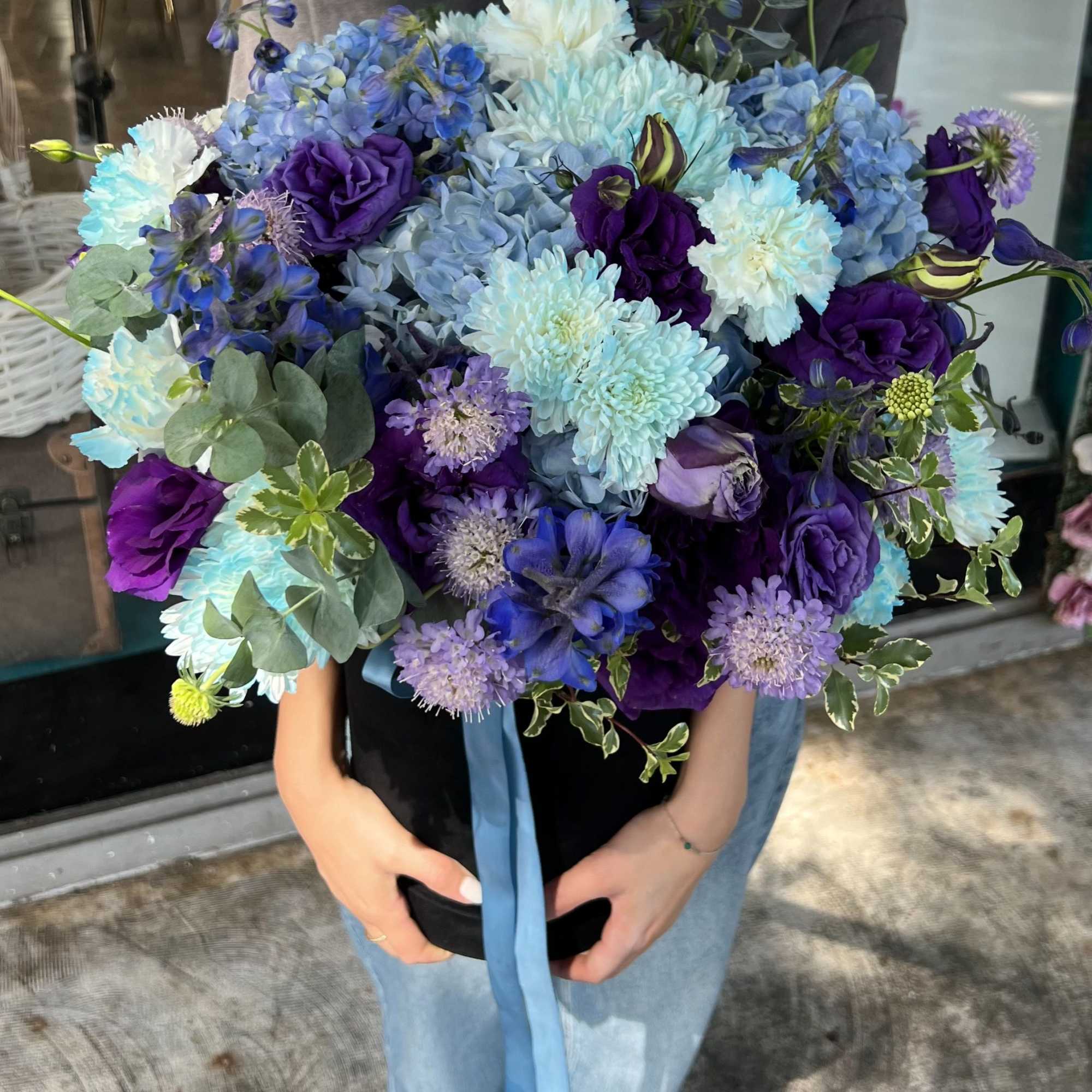 Large bouquet of blue and purple flowers with a ribbon tie
