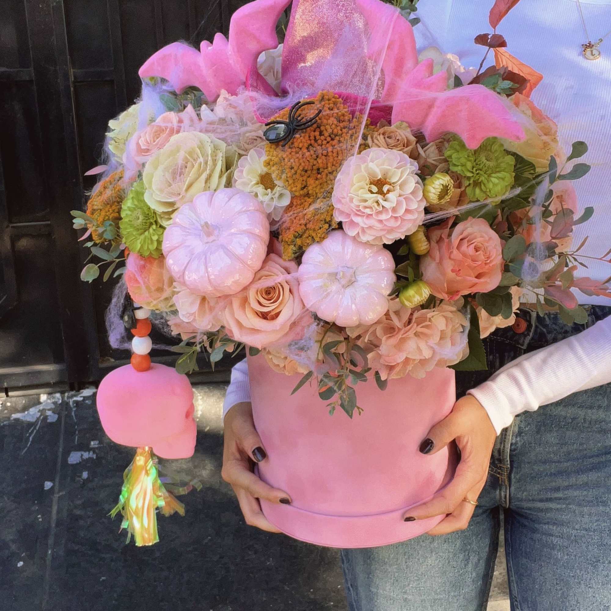 Pink floral arrangement in a round box with a tall glittery topper