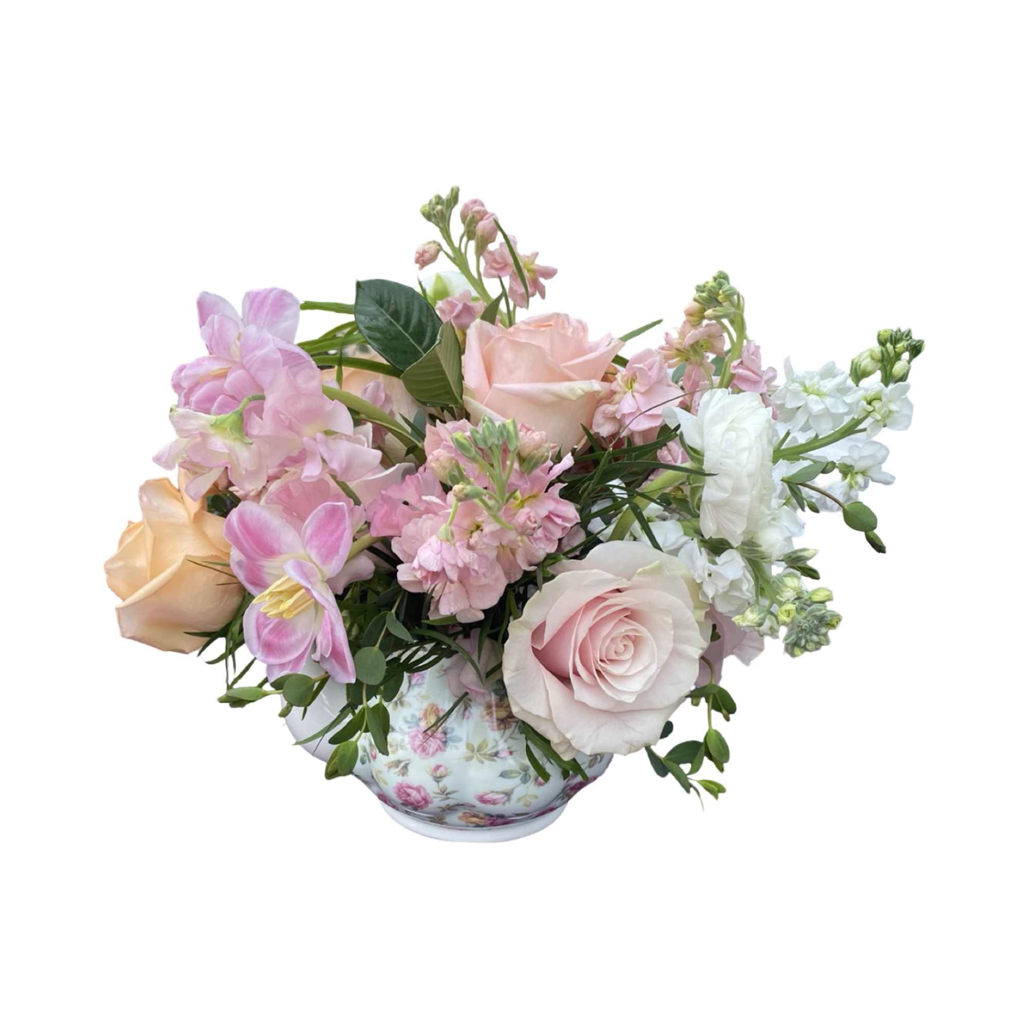 Pink and white floral arrangement in a floral teacup vase
