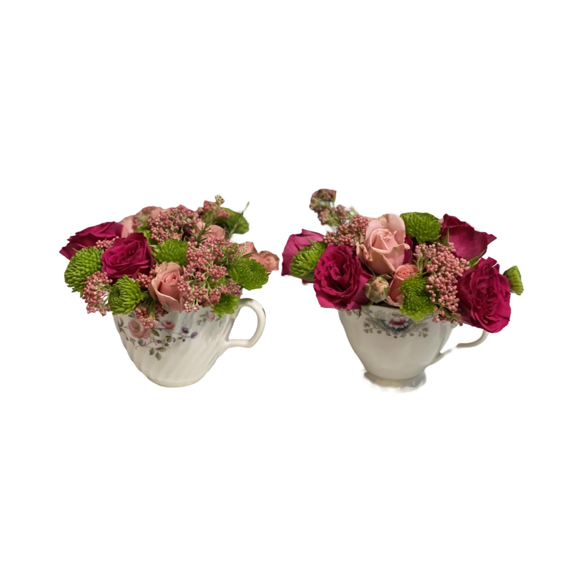 Two small floral arrangements in teacups with pink and magenta roses