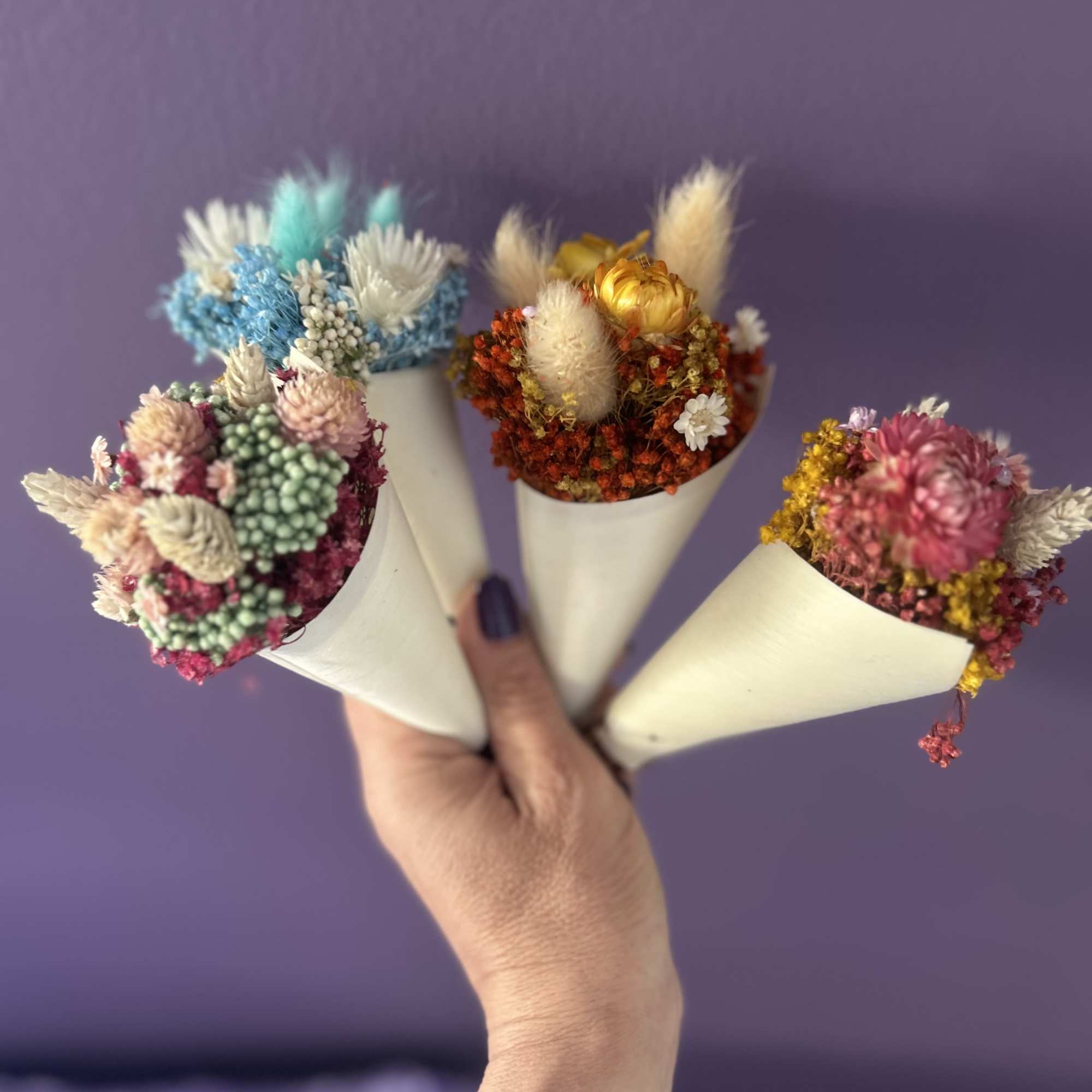 Four small dried flower bouquets wrapped in white paper