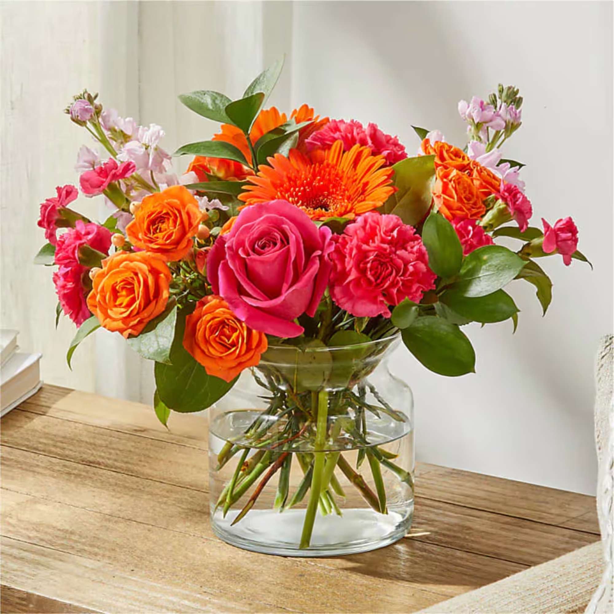 Bouquet of pink and orange flowers in a clear glass vase