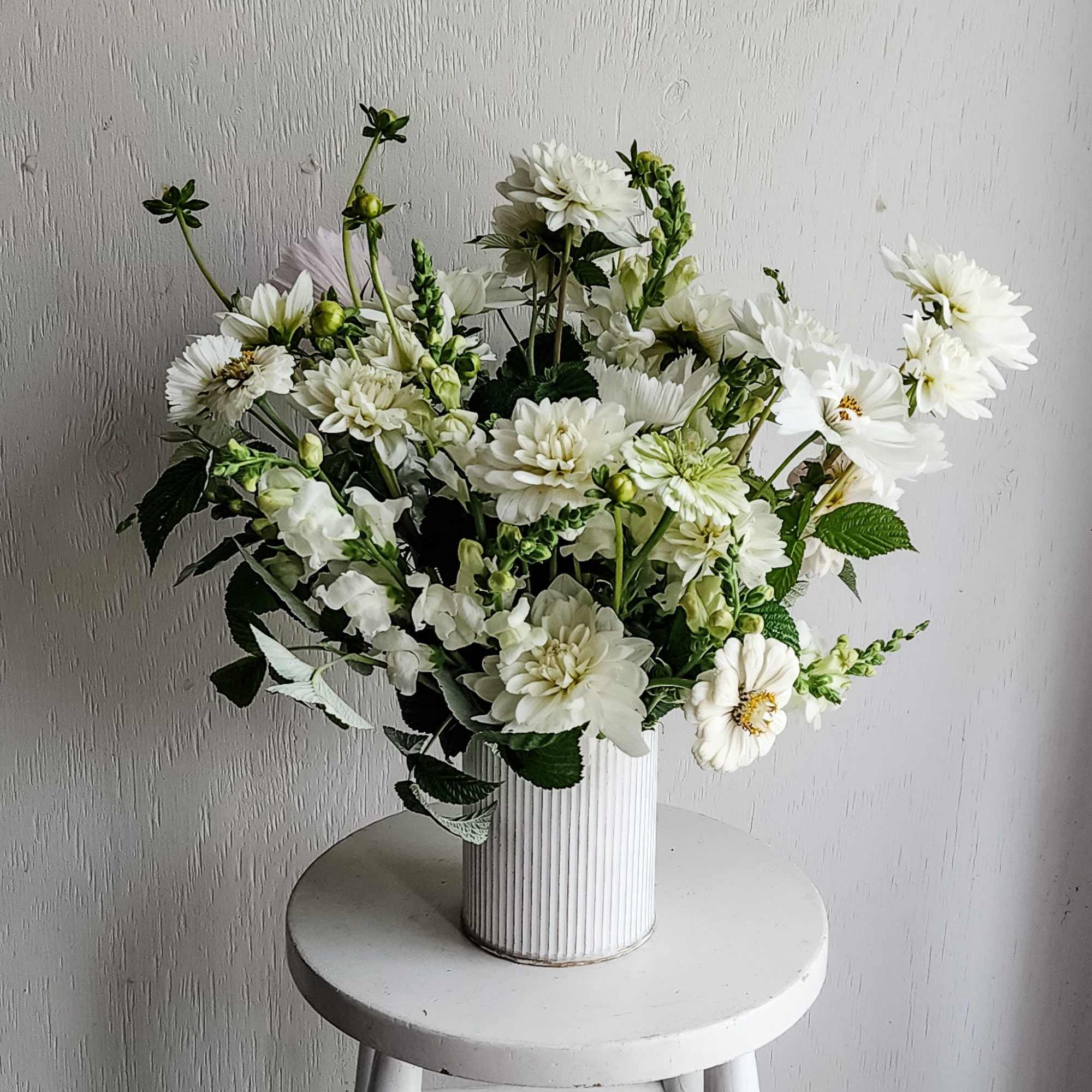 White flower arrangement in a ribbed white vase