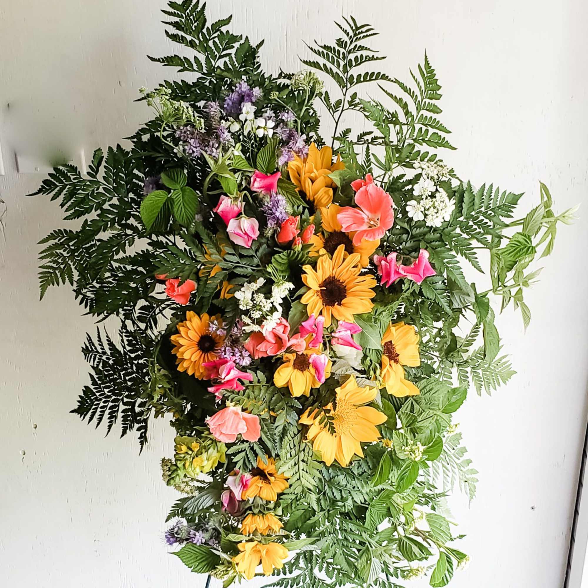 Standing floral spray with yellow daisies and pink blooms