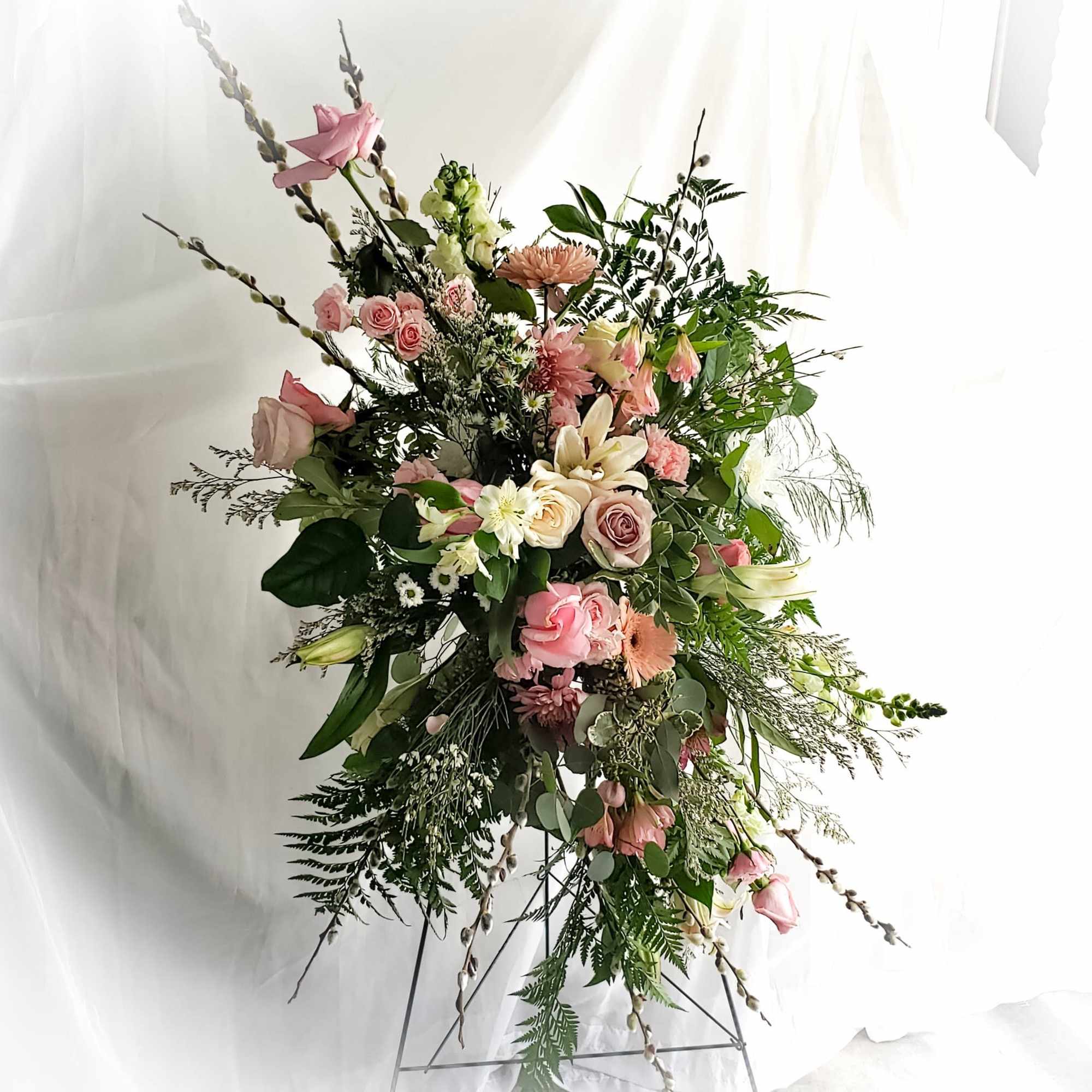 Large pink and white floral spray on a metal stand