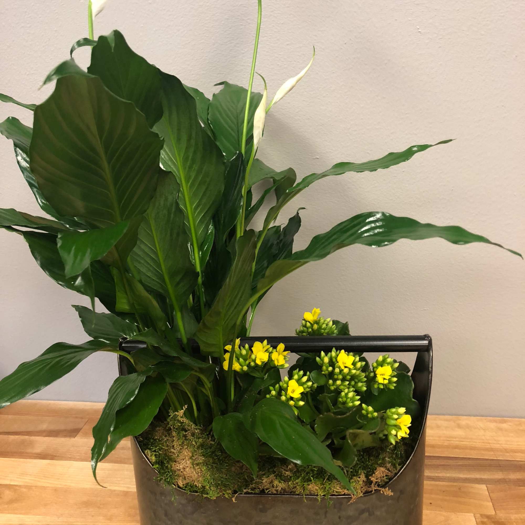 Potted arrangement with white calla lilies and yellow flowers in a metal container