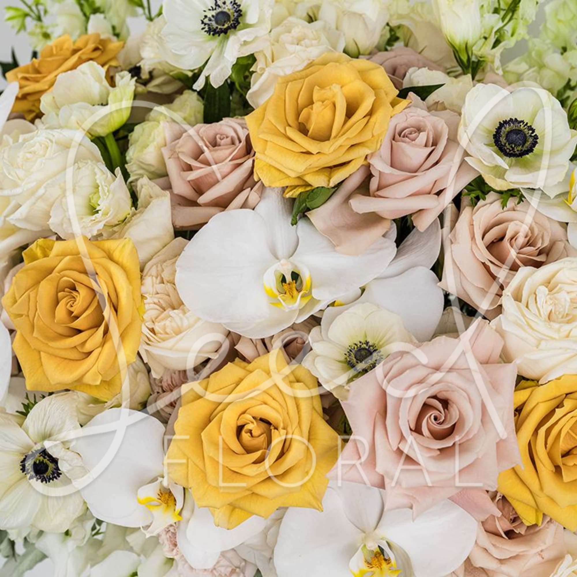 Bouquet of yellow and blush roses with white orchids and anemones