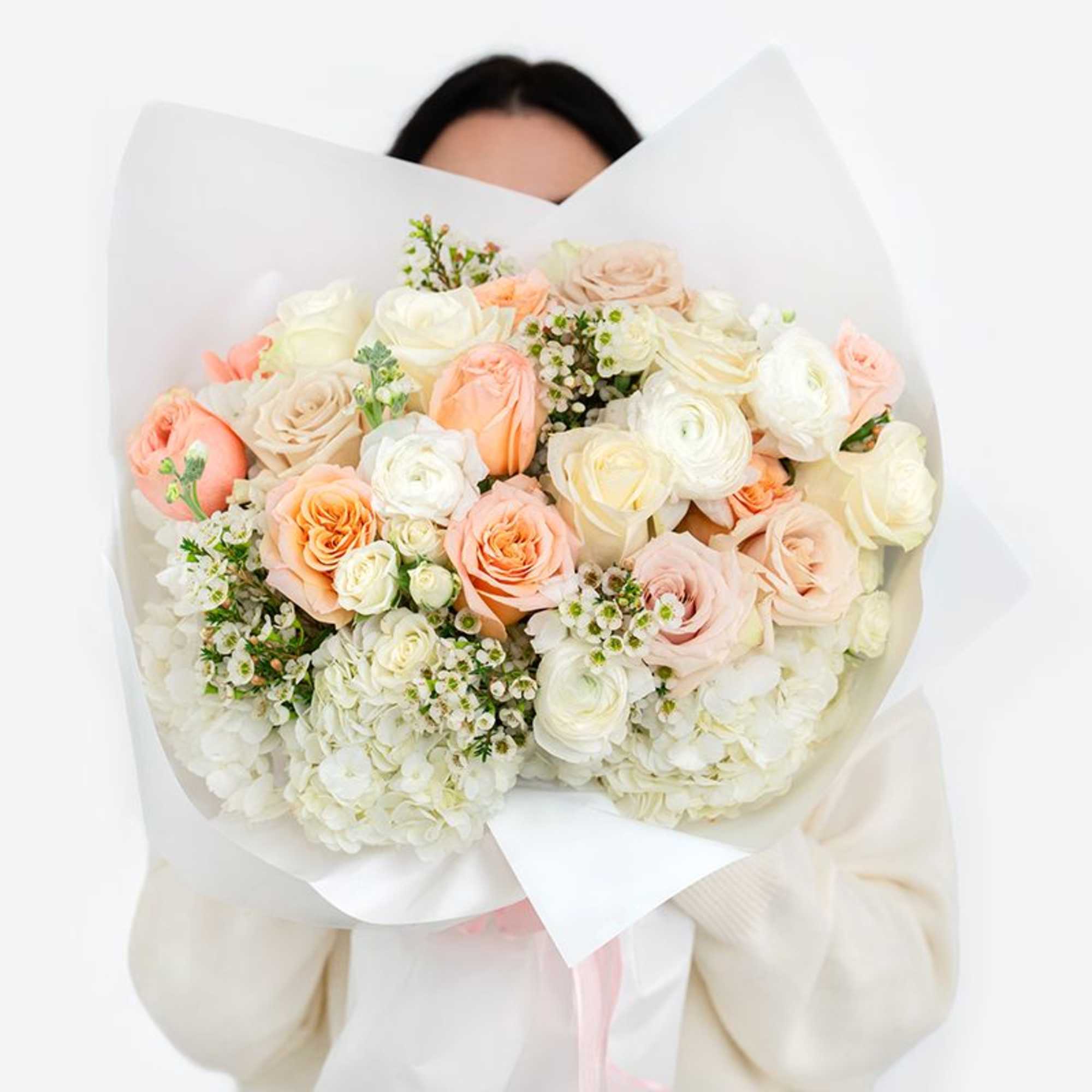 Large bouquet of blush, peach, and white roses wrapped in white paper, photo 3 of 3