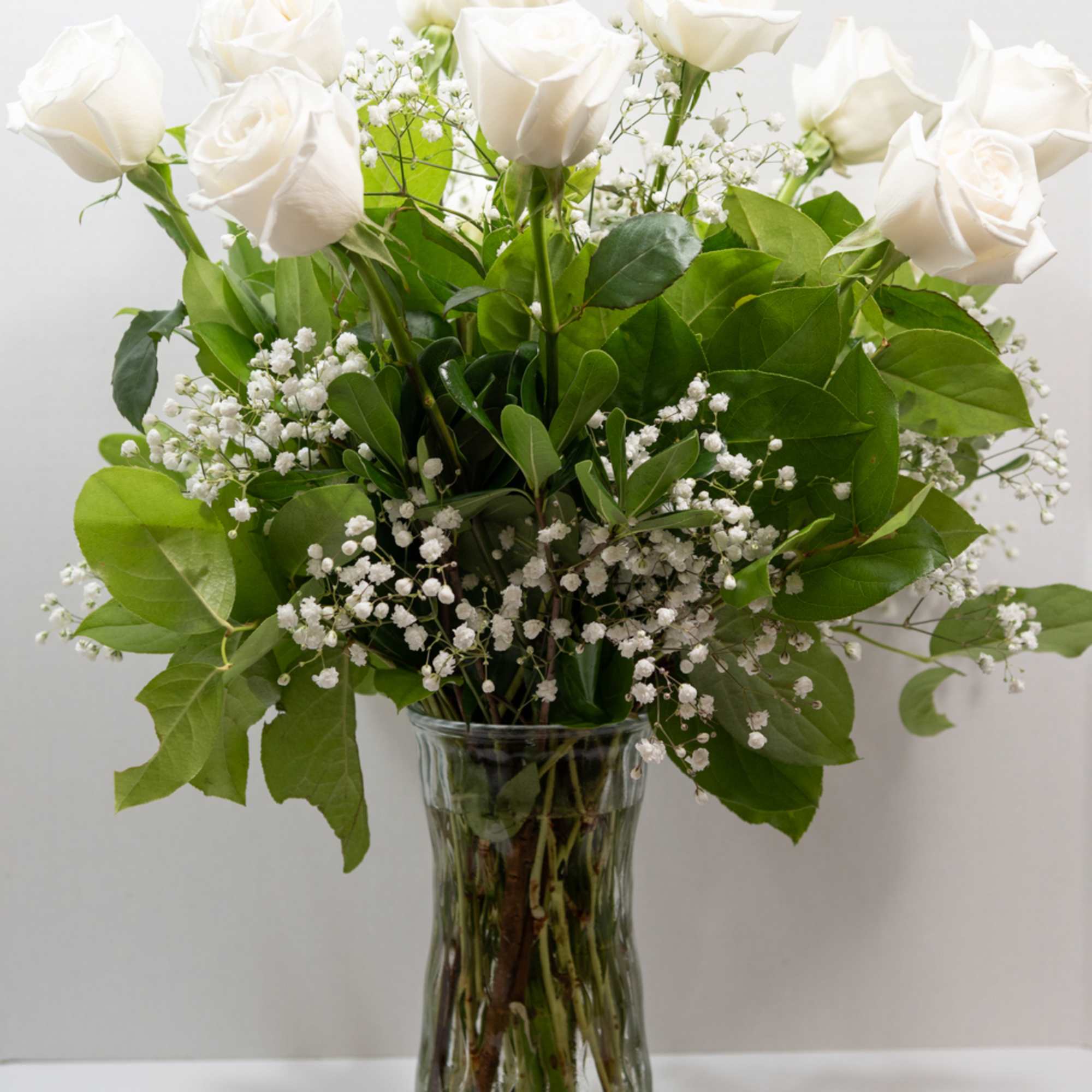 A graceful bouquet of white roses, framed by baby's-breath filler. The sophisticated