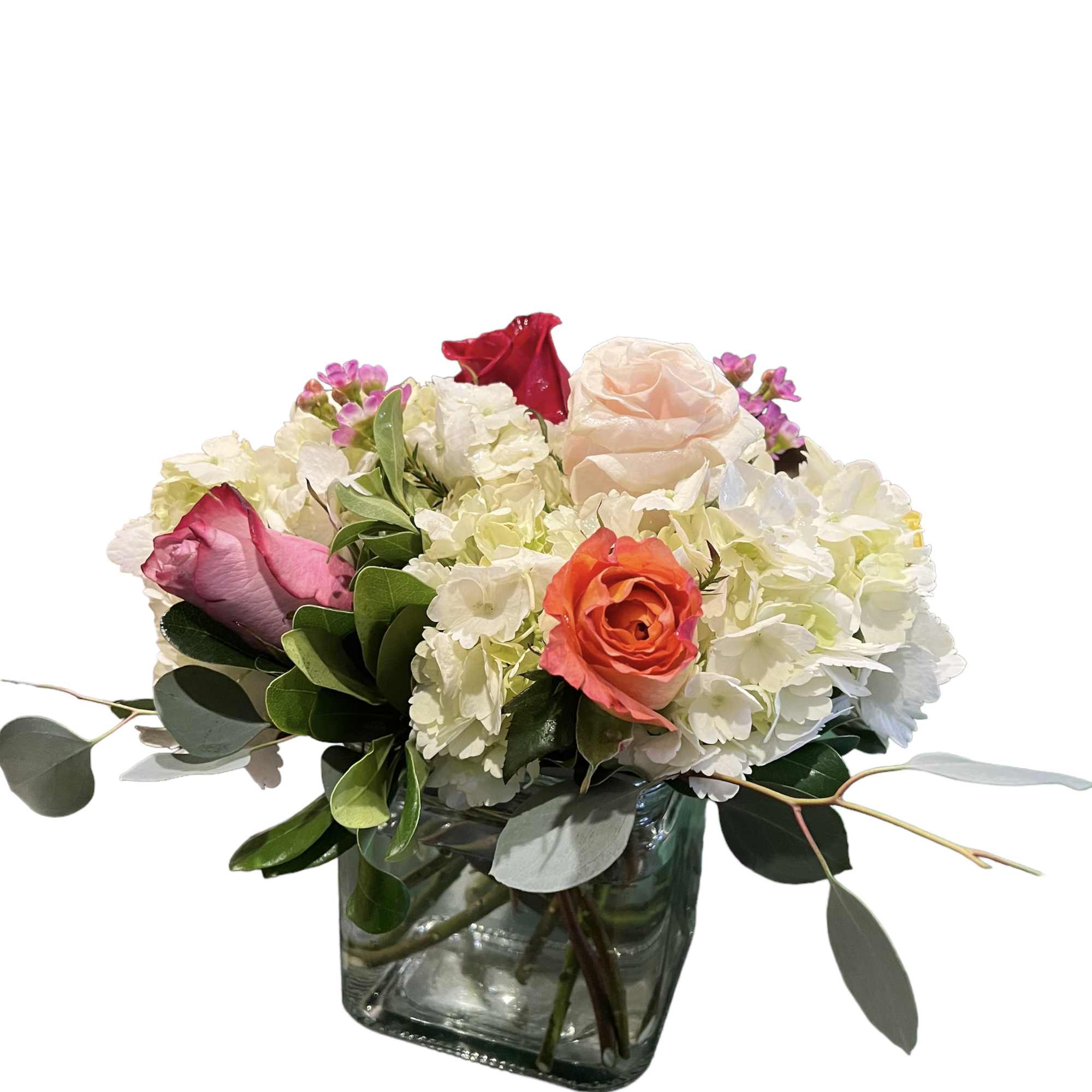 Mixed bouquet of roses and white hydrangeas in a glass vase