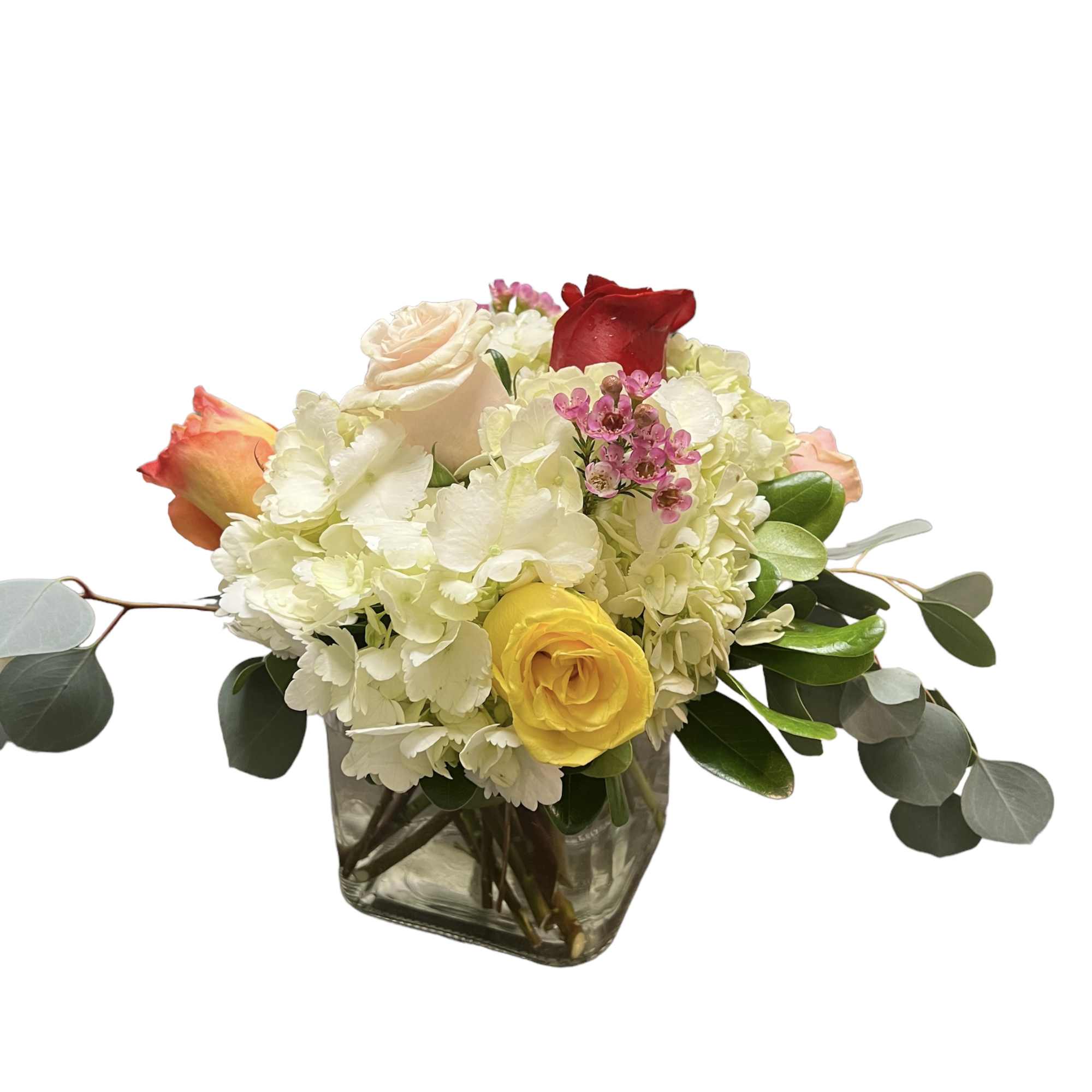 Mixed bouquet of roses and white hydrangeas in a square glass vase